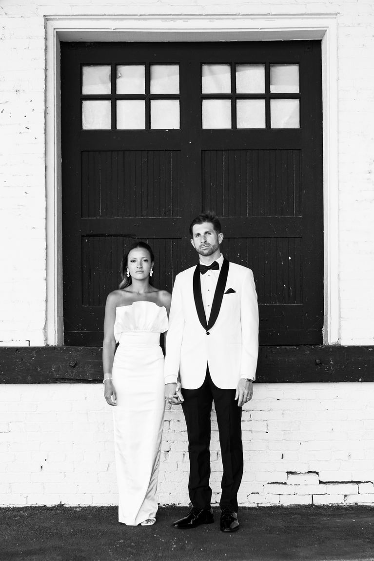 A couple in black and white standing in a doorway