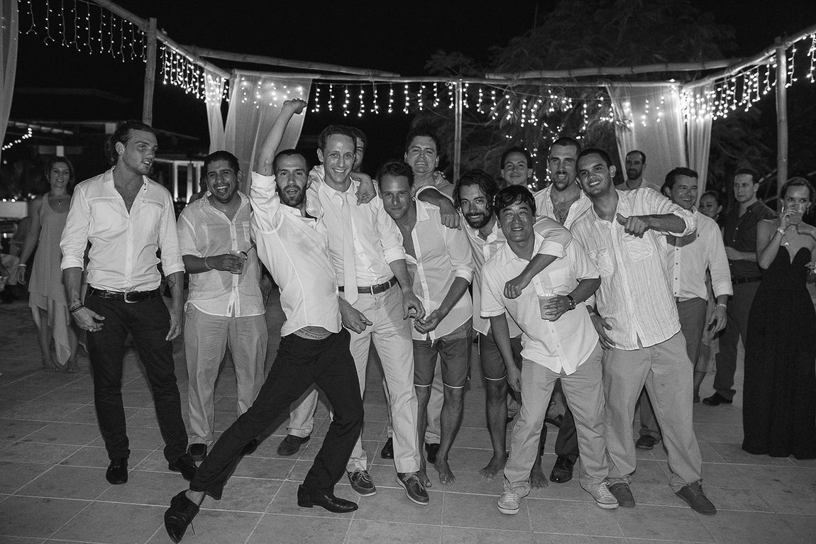 Guests dancing under string lights, in black and white