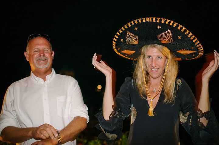 A wedding guest in an enormous black-and-gold sombrero, guest 1 of 29
