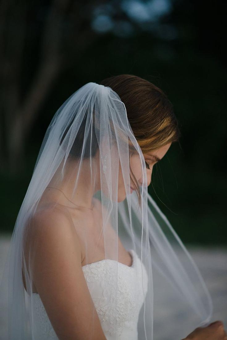 A bride in her veil, eyes lowered