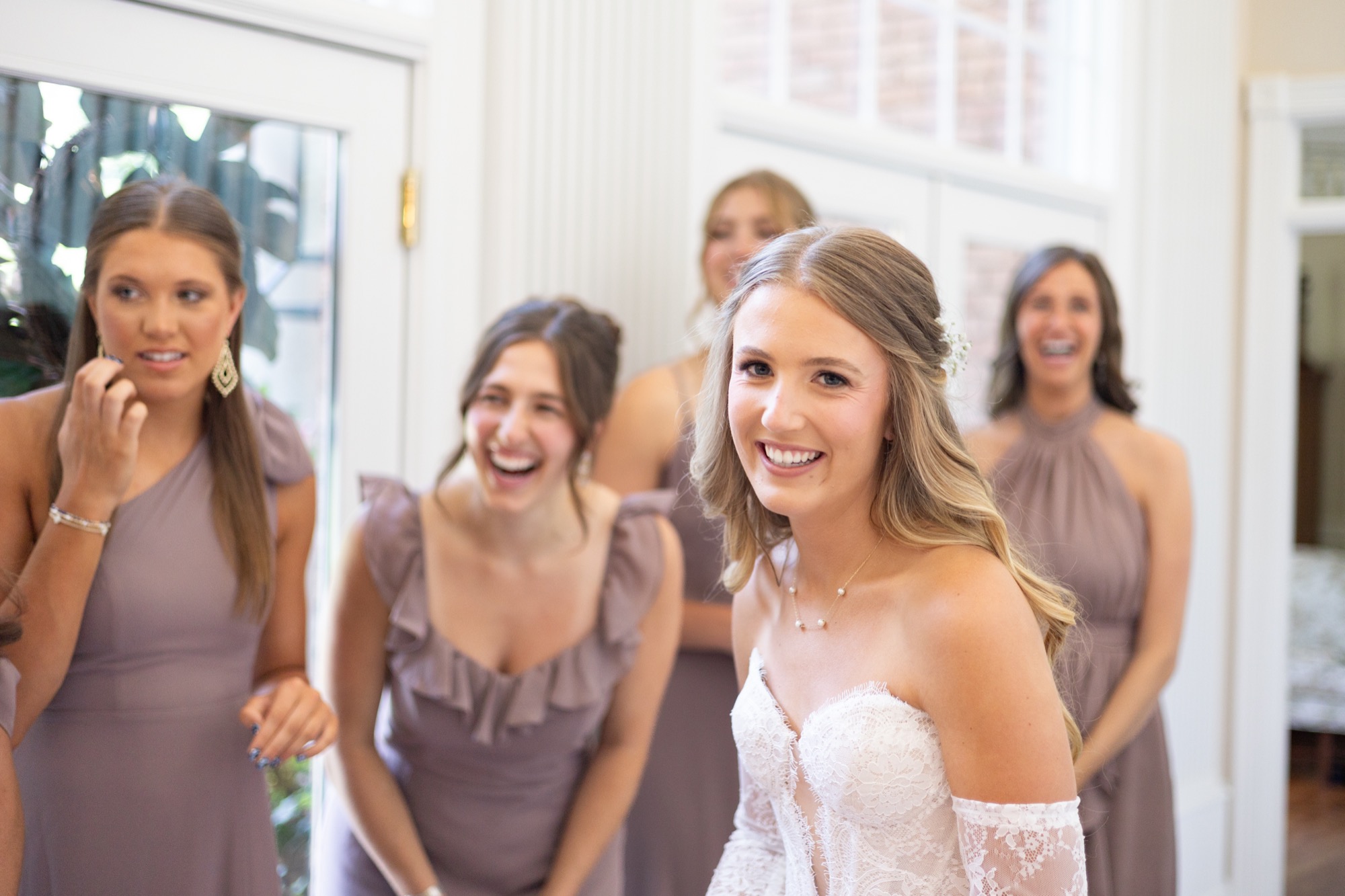 Bridesmaids laughing with the bride
