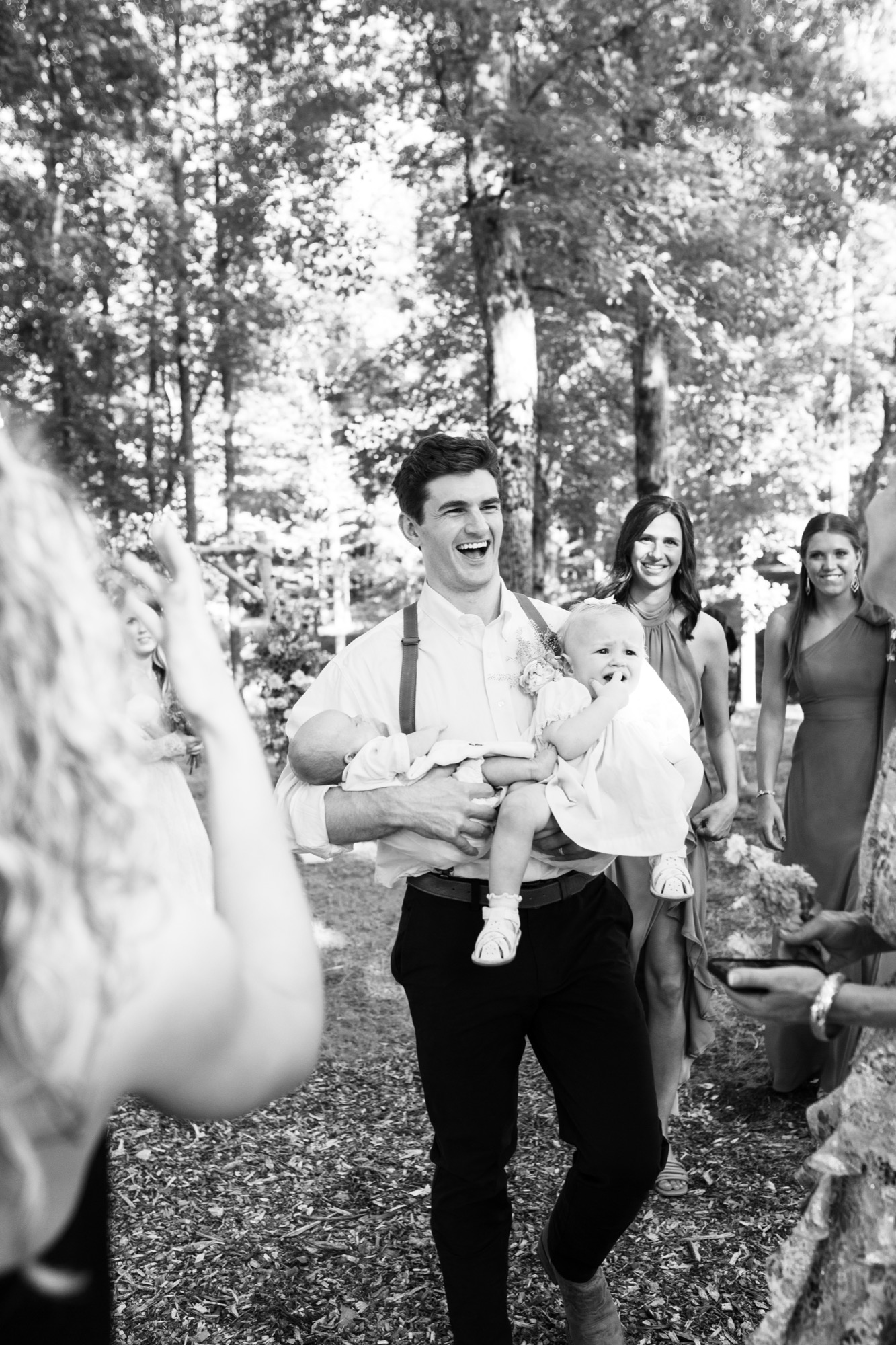 The groom and guests in the aisle, in black and white