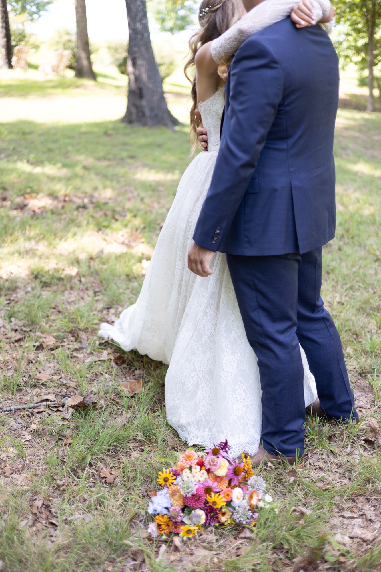 The couple embracing, bouquet at their feet