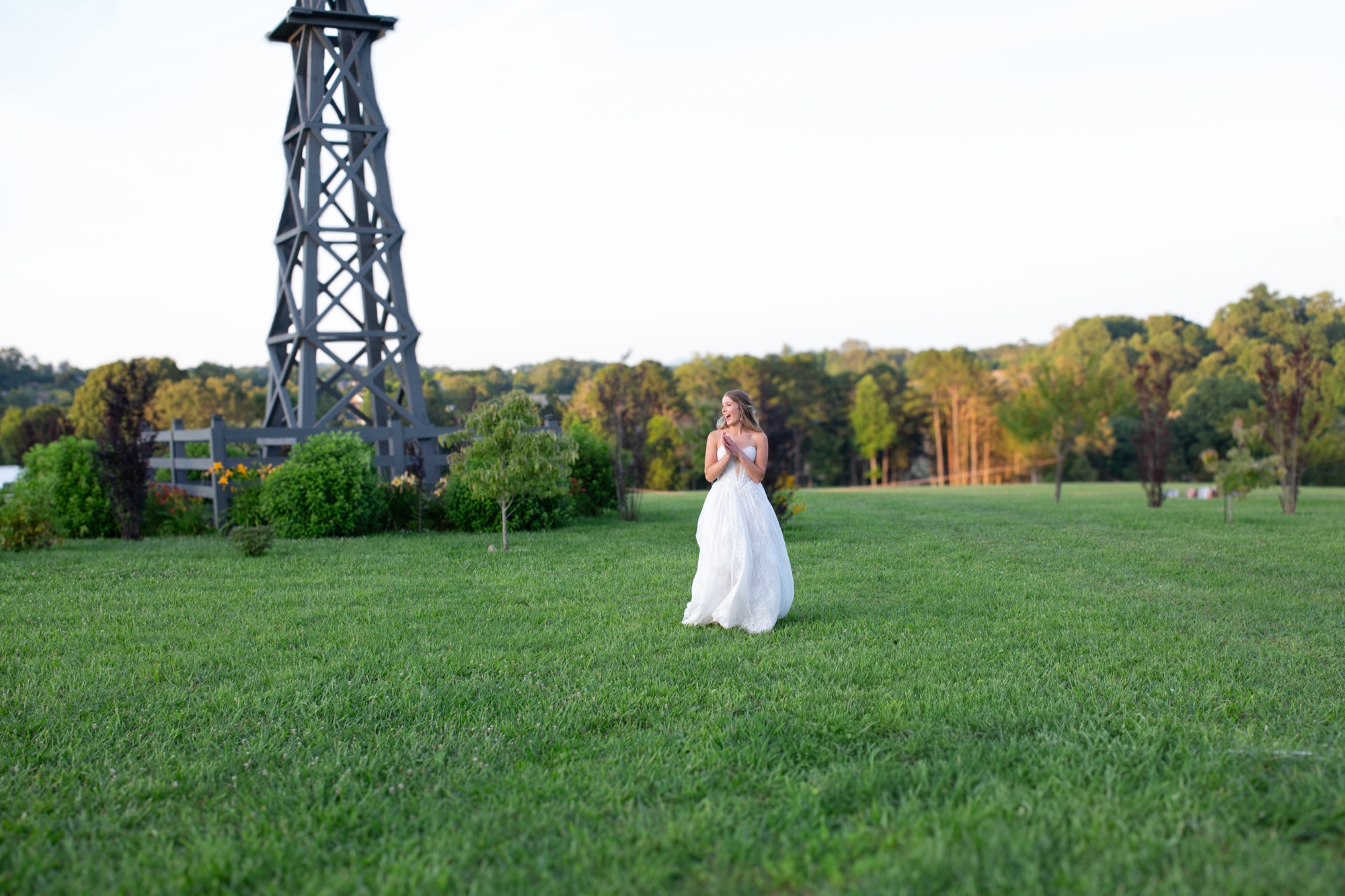 The bride small on the lawn below the windmill