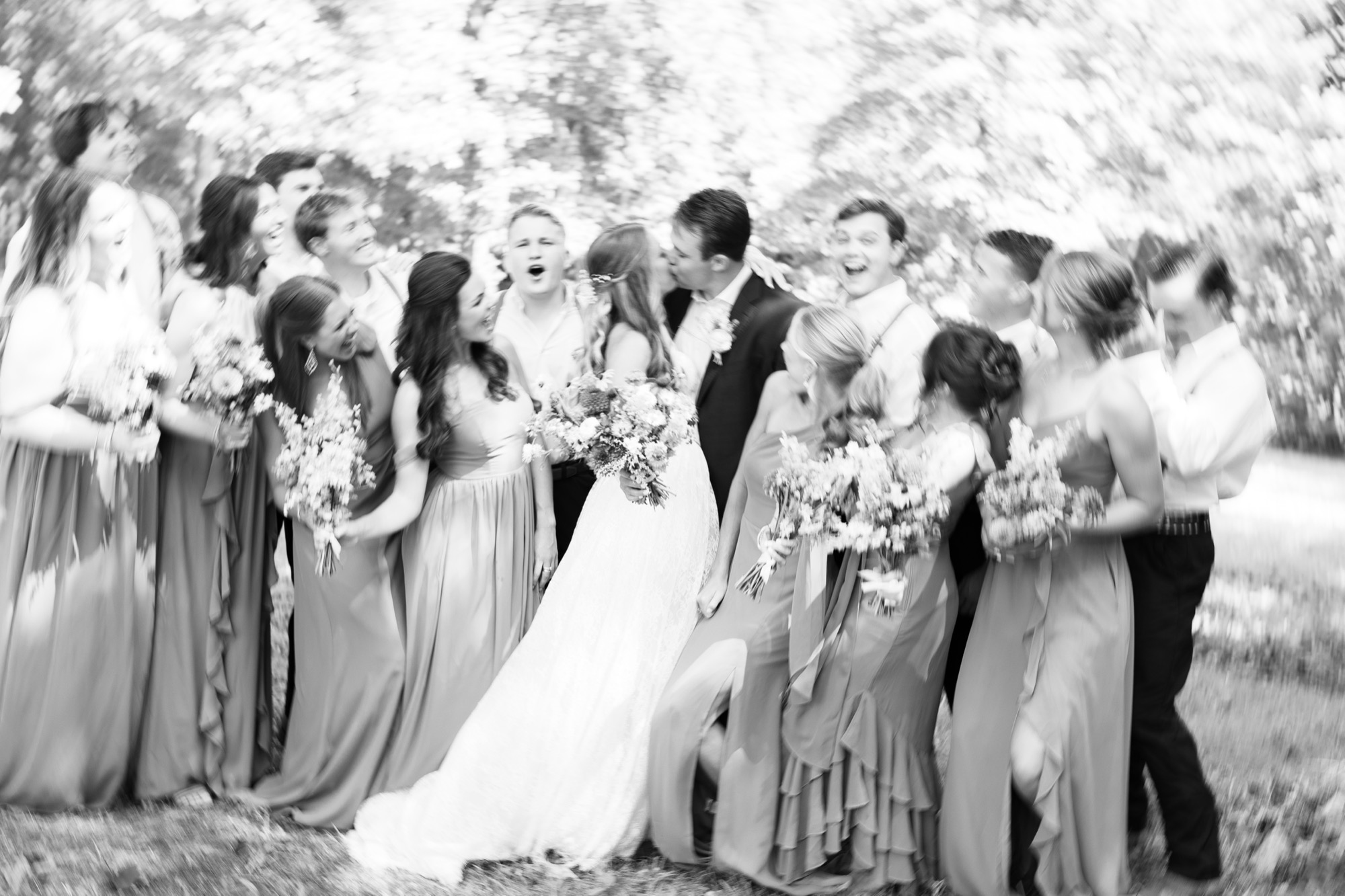 The wedding party piled together, in black and white