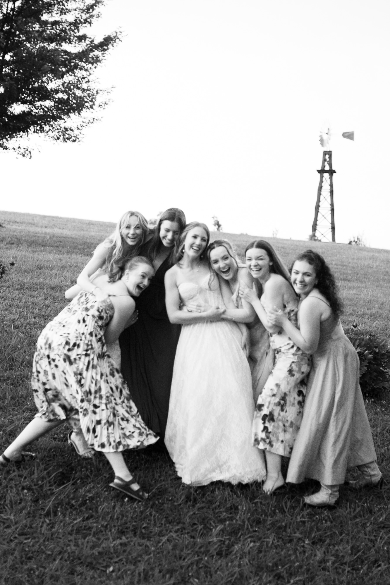 The bridesmaids leaning in, the windmill behind them, in black and white