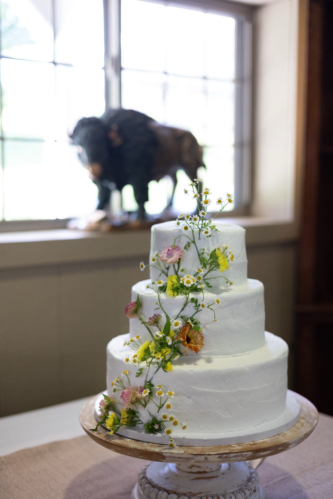 The wedding cake, with a bison figure in the window behind it