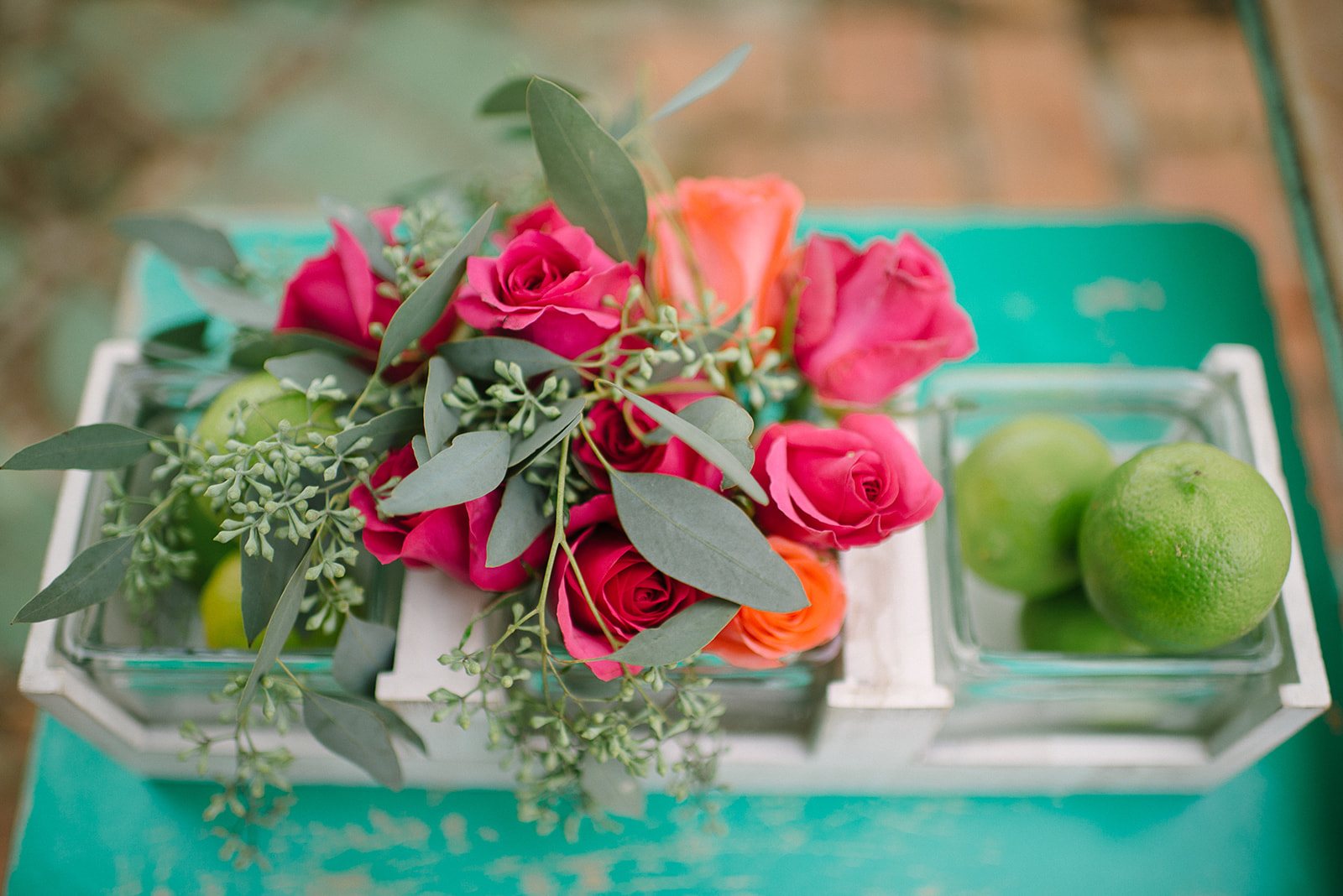 Pink roses and limes on a turquoise table
