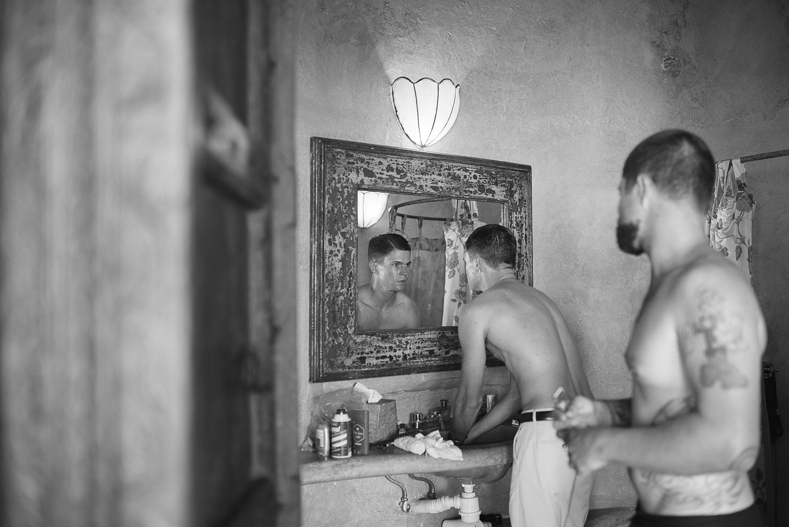 The groomsmen shaving at the mirror, in black and white