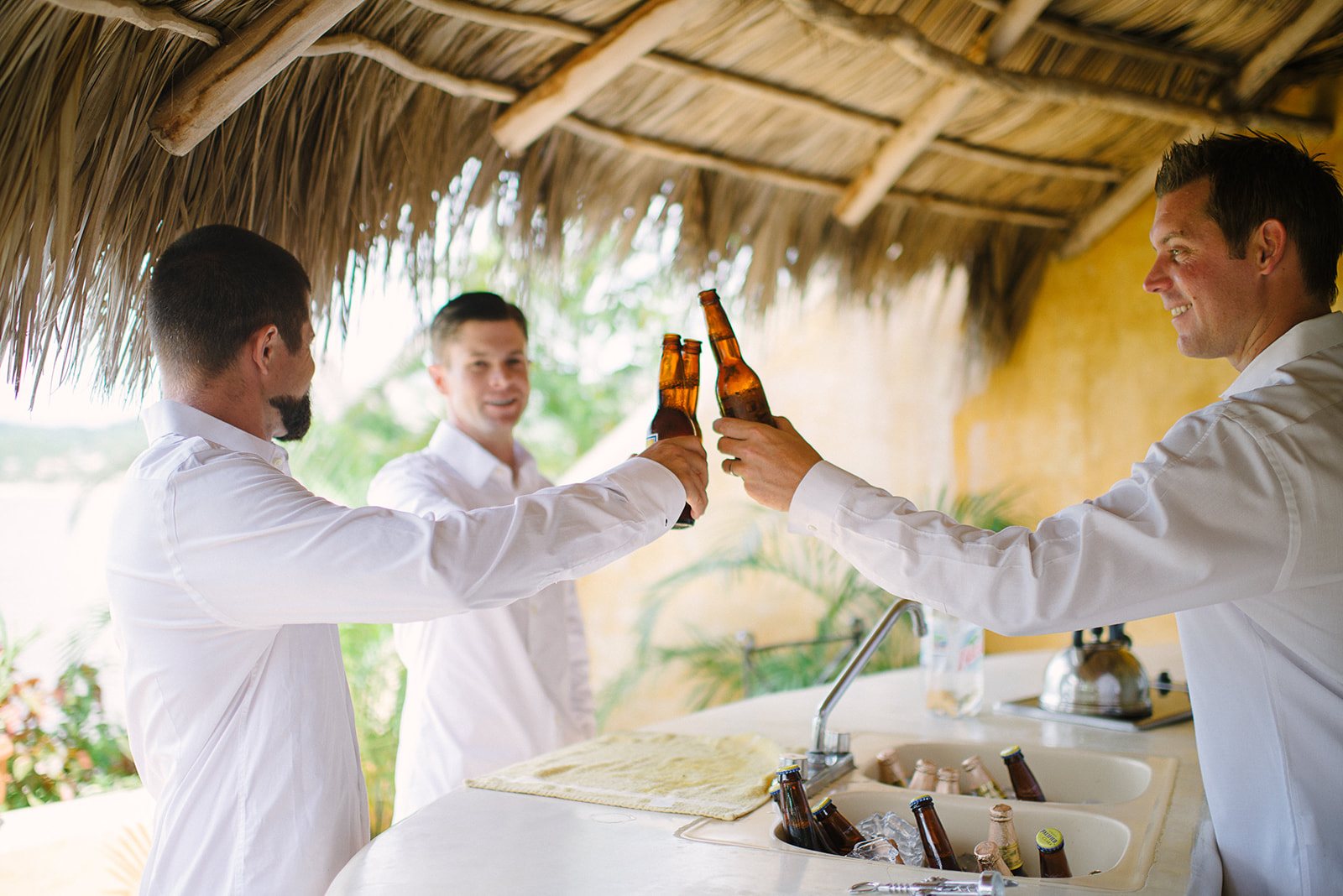 The groomsmen clinking beers at the bar