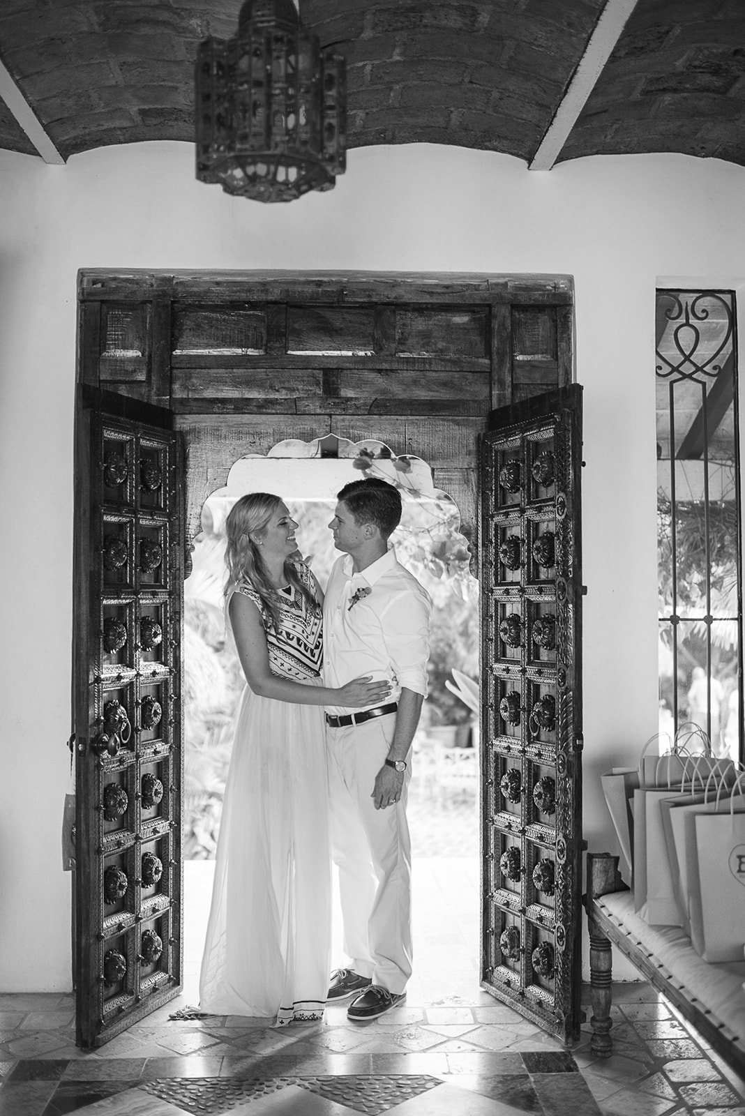 The couple framed in a carved doorway, in black and white