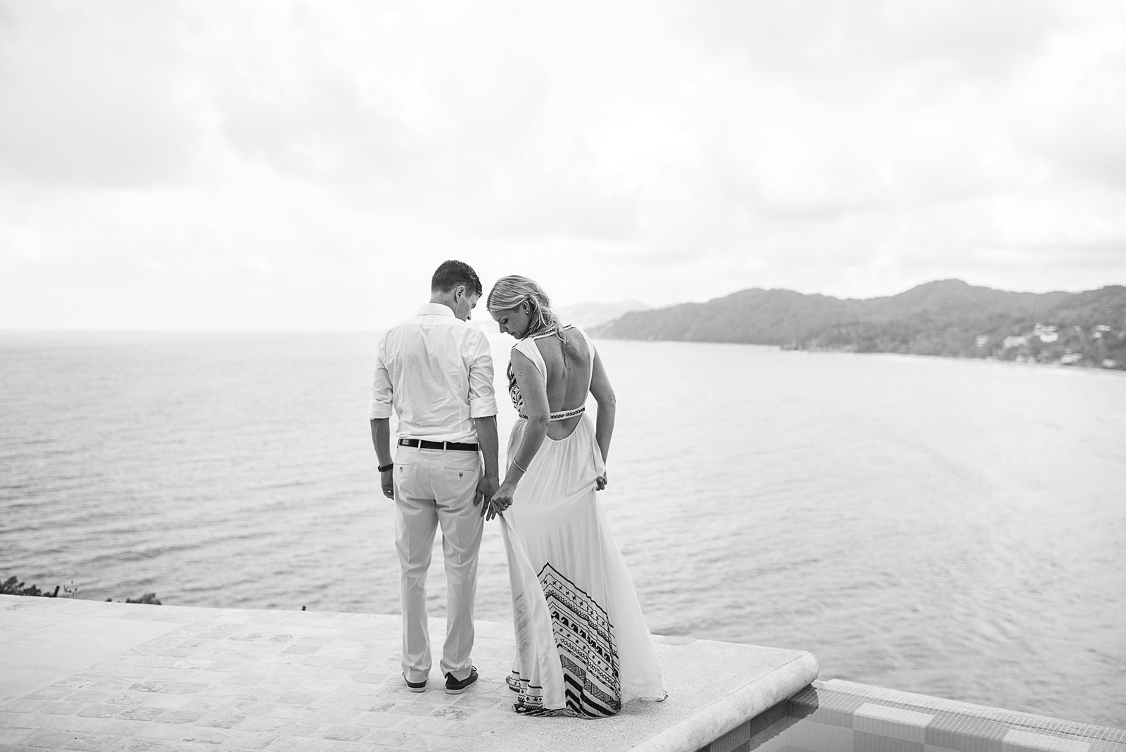The couple on the edge of the infinity pool above the bay
