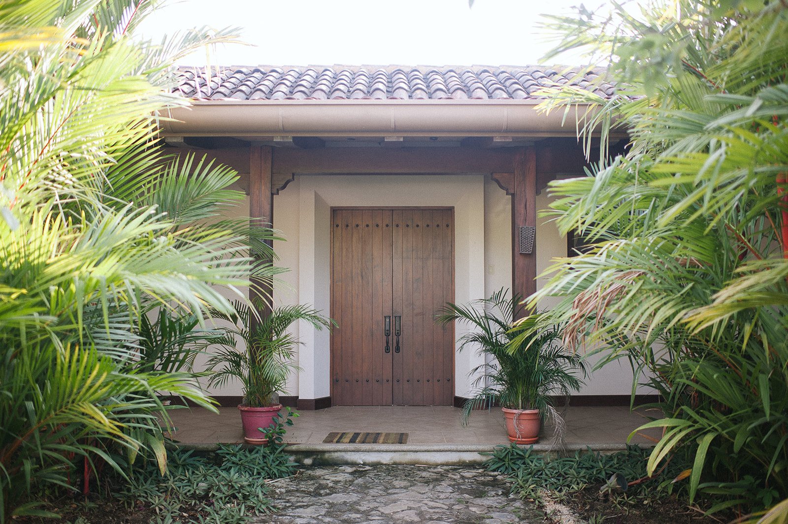 The front door of the beach house among the palms