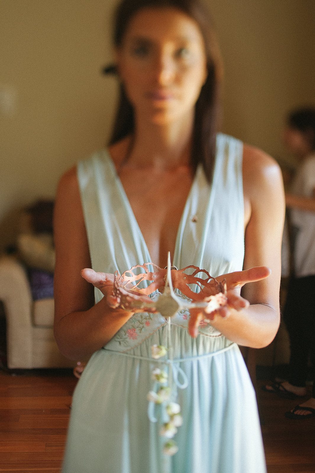 The bride in a pale blue robe, holding her jewelry