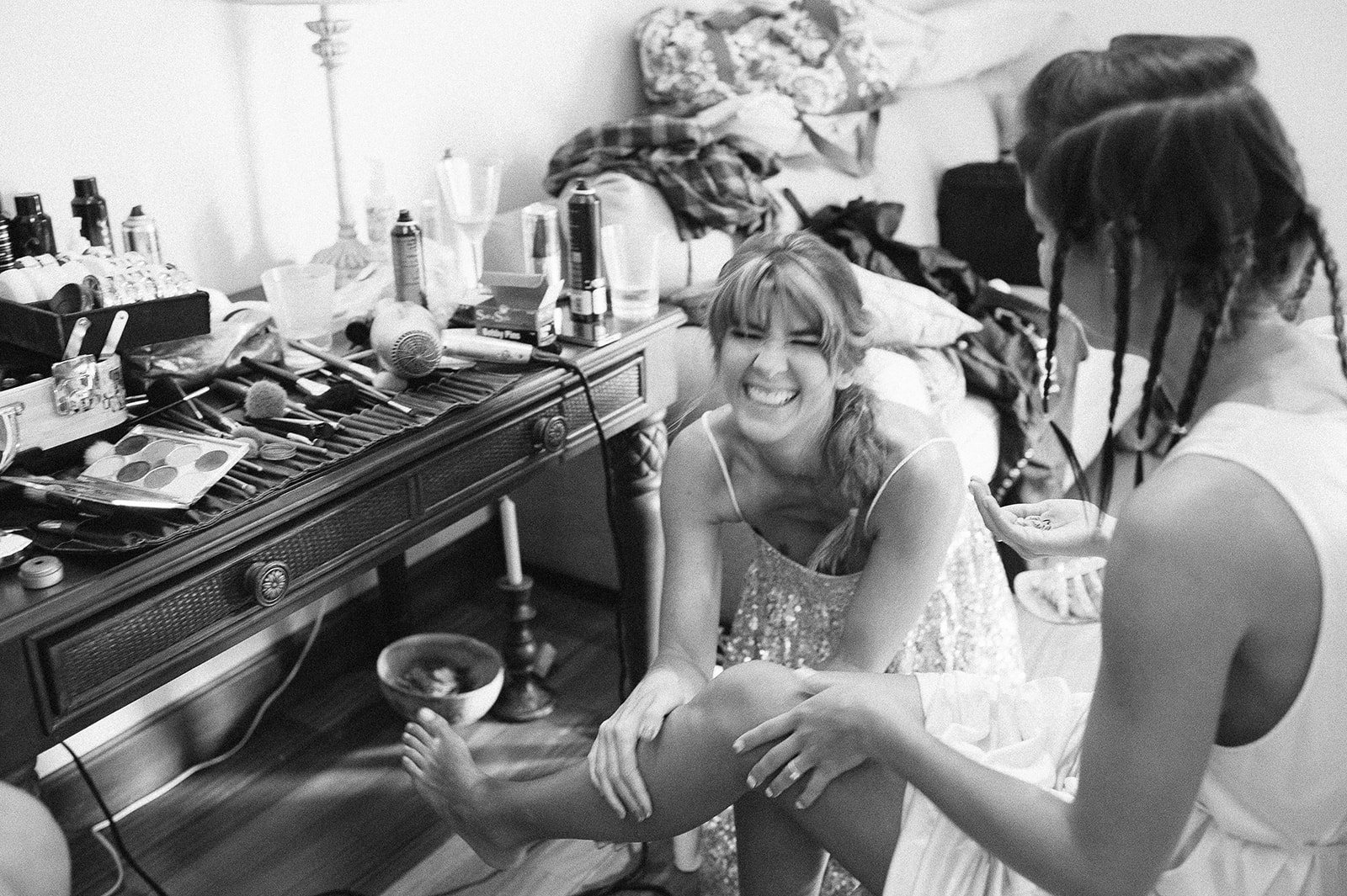 Friends helping the bride get ready, in black and white