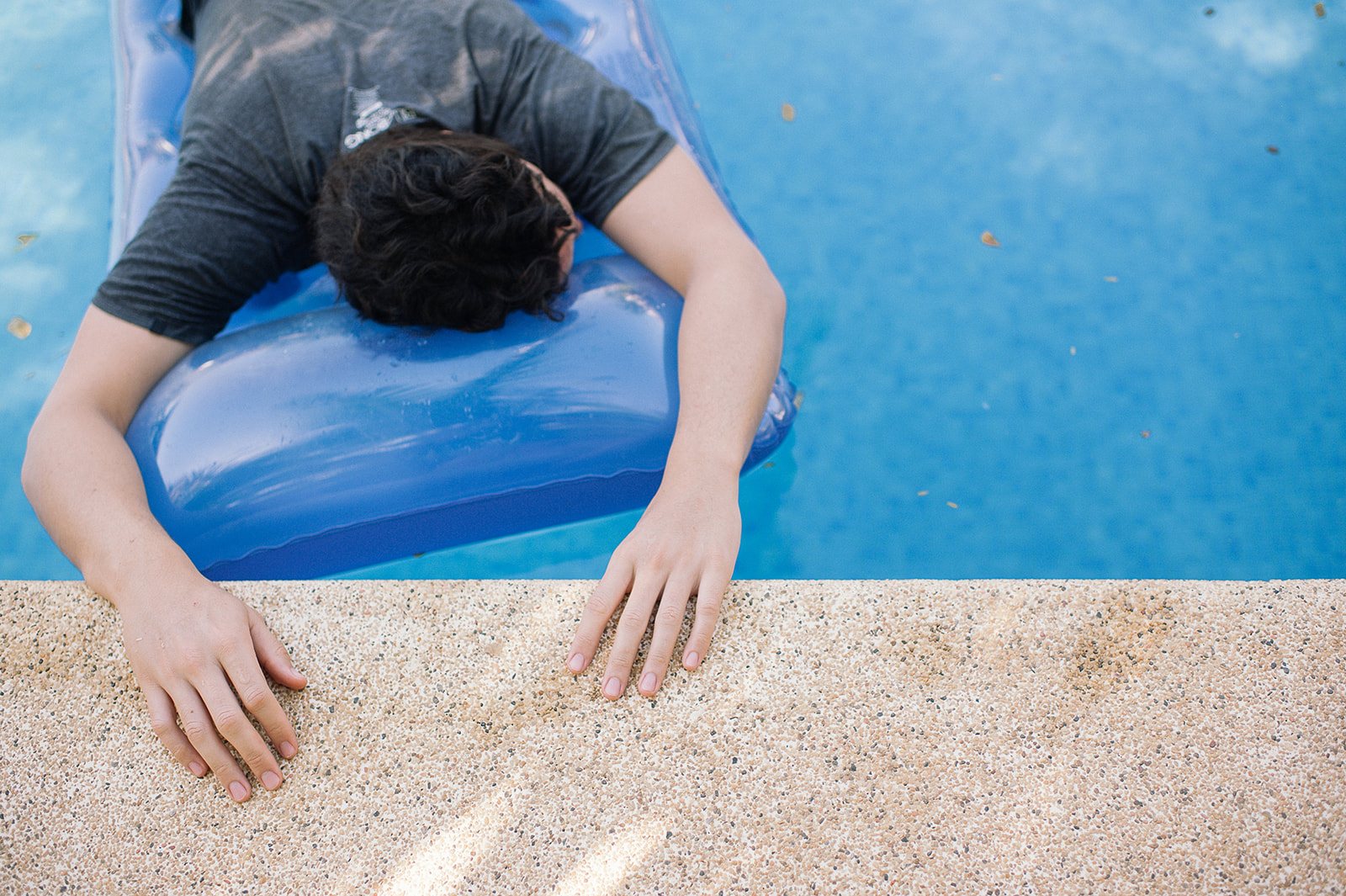 A guest face down on a blue pool float