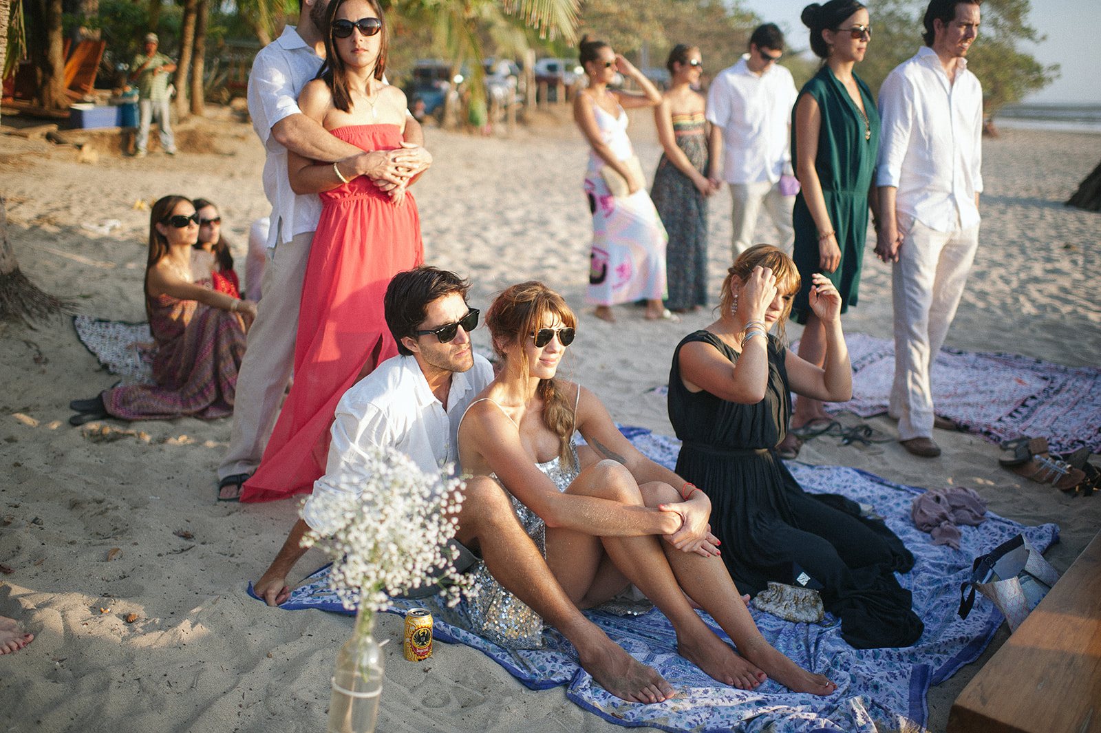 Guests sitting on blankets in the sand