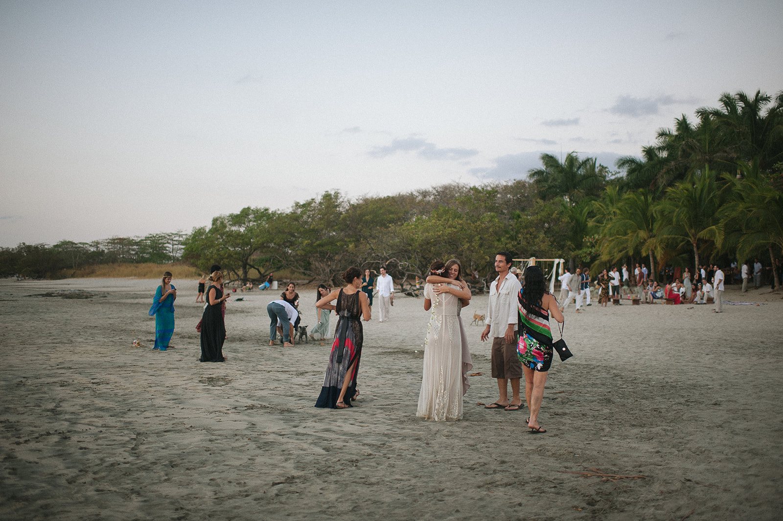 Guests scattered along the beach at dusk