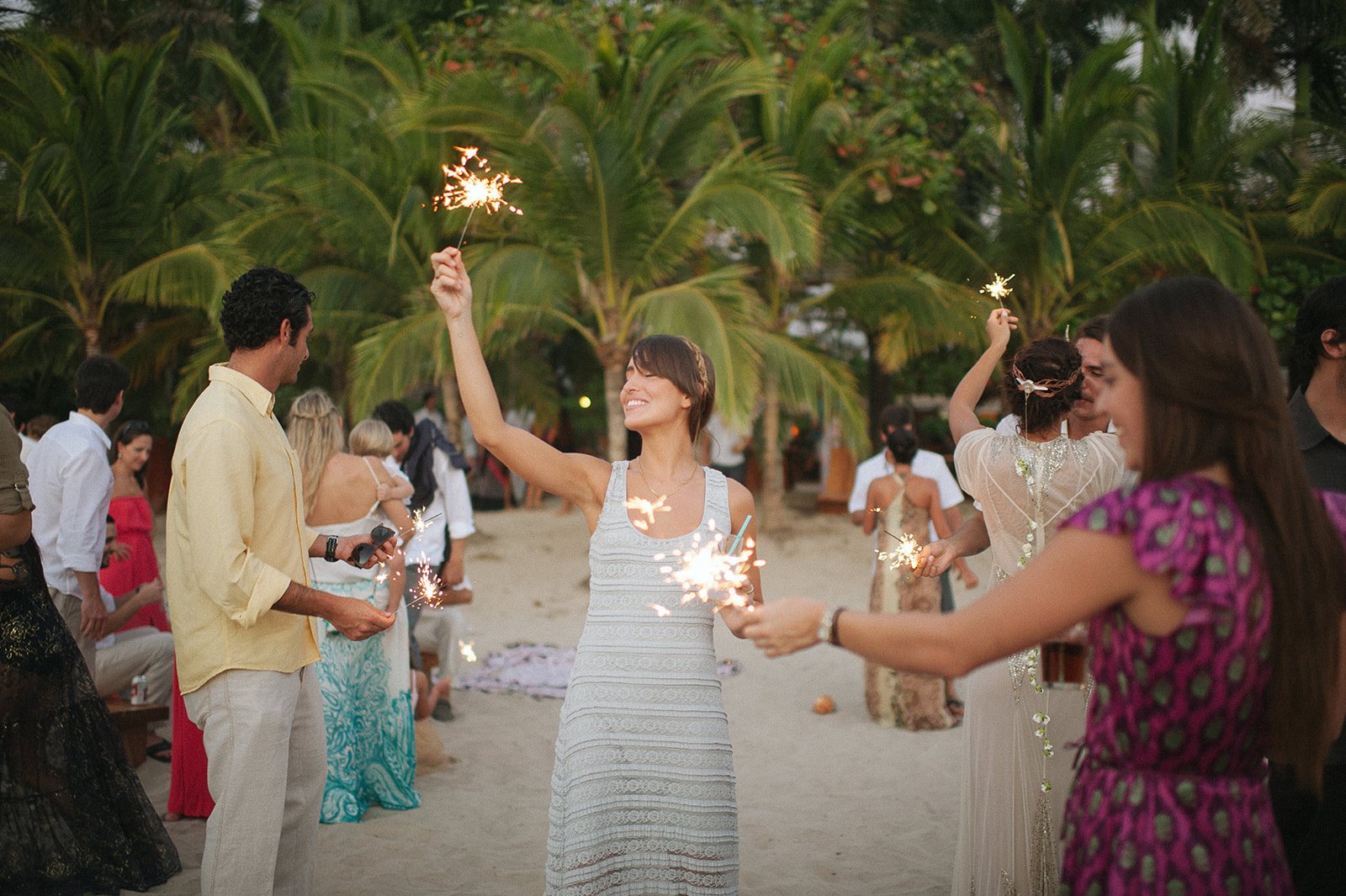 The bride with a sparkler, friends cheering