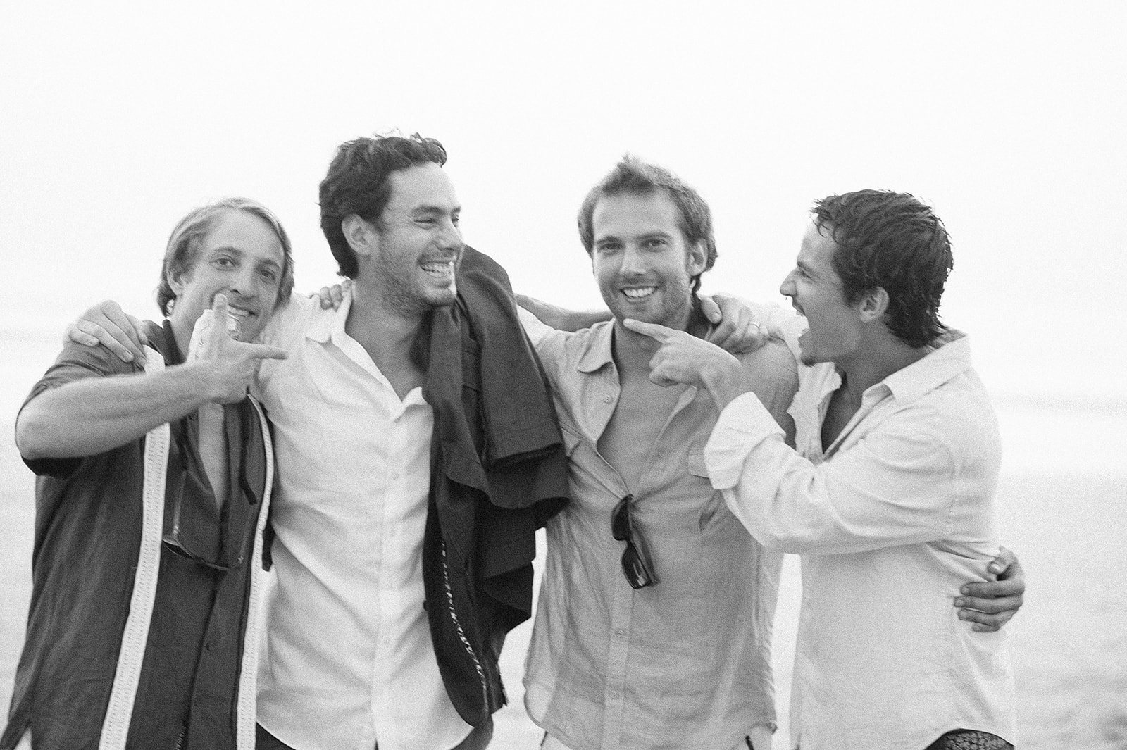 Four friends on the beach in black and white