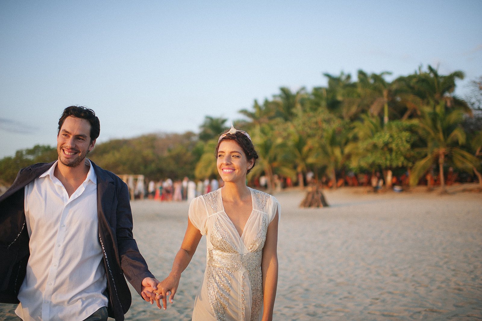 The couple walking up the beach, palms behind