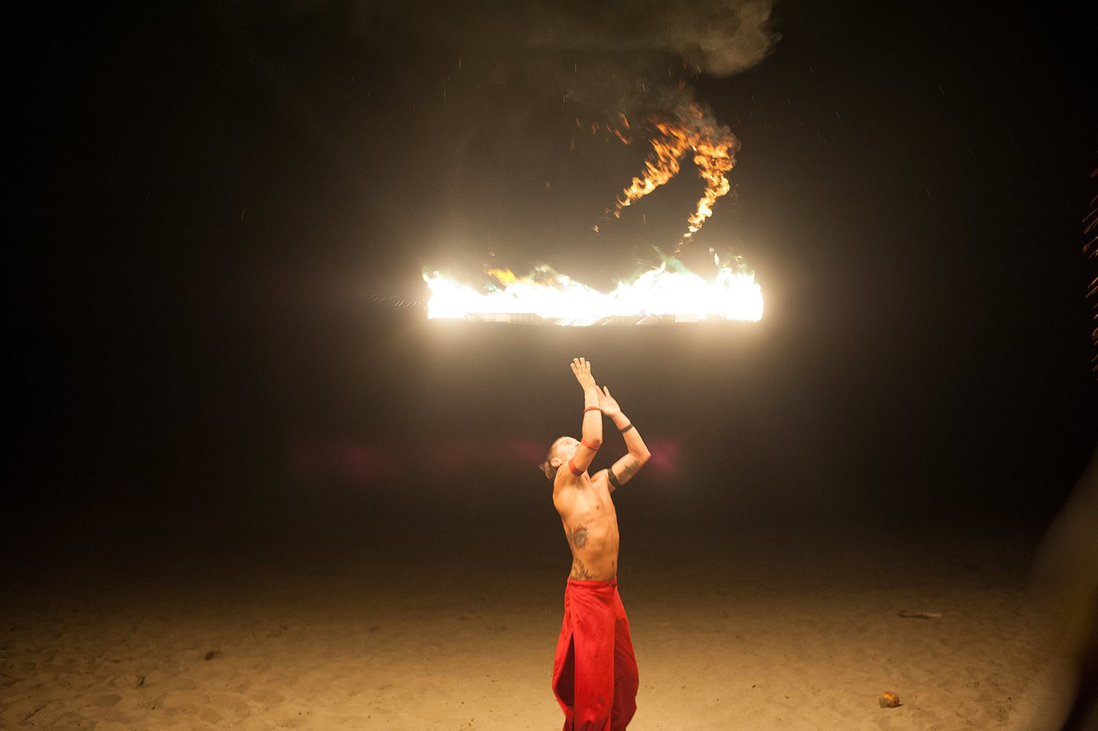 A fire dancer spinning flame on the beach
