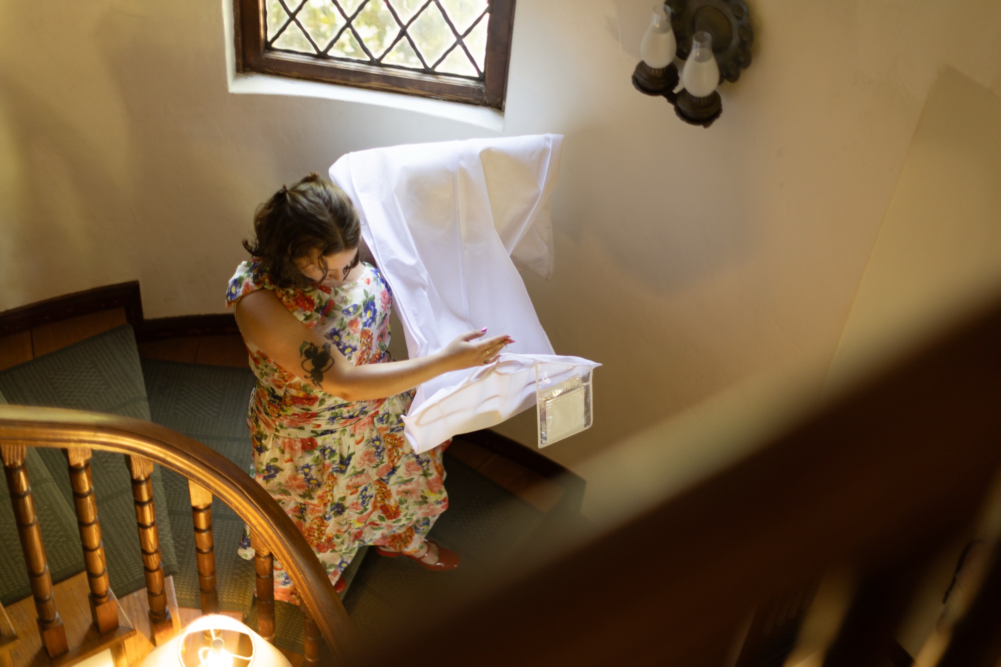 A guest in florals on the staircase landing, seen from above