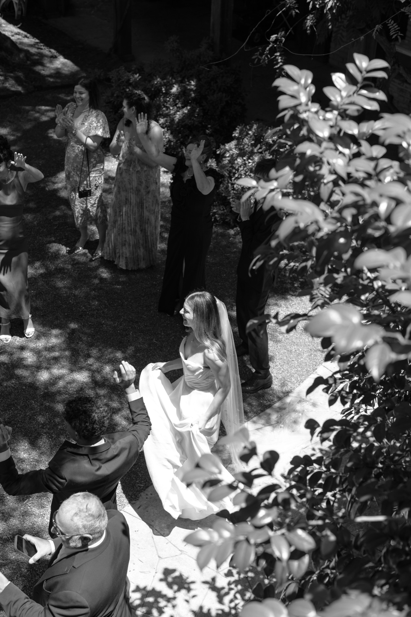 The bride under dappled leaves, in black and white