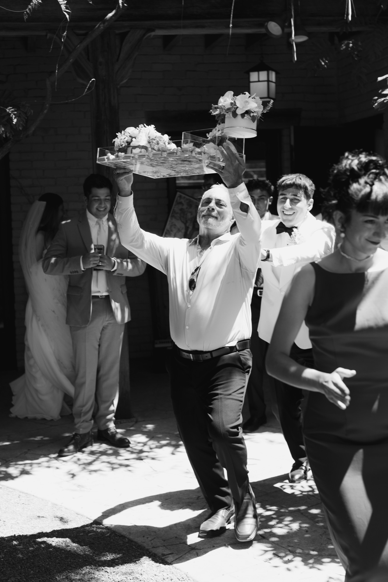 A guest carrying a tray above the crowd, in black and white