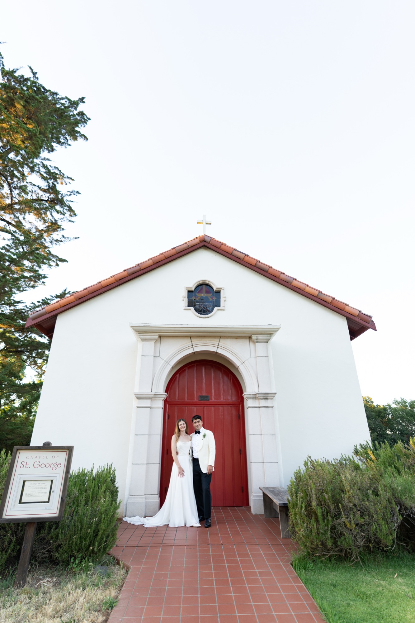 The couple at the red door of the white chapel