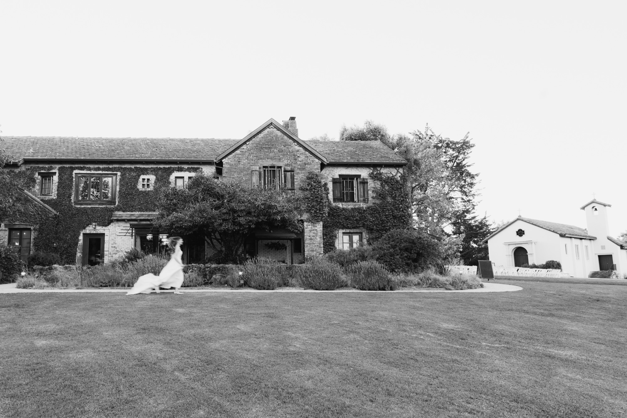 The ivy-covered lodge and lawn, in black and white