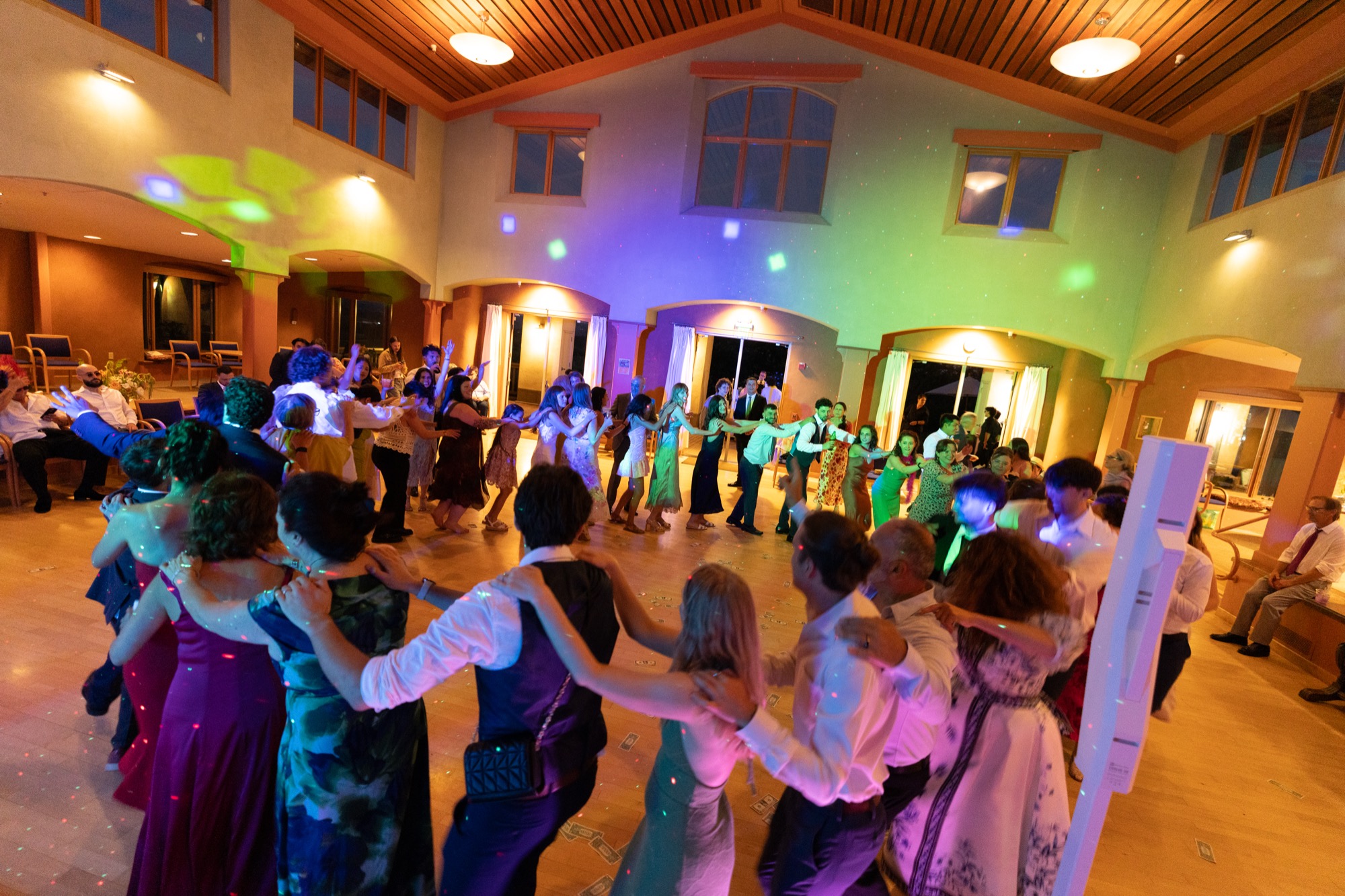 A circle of dancers under colored lights