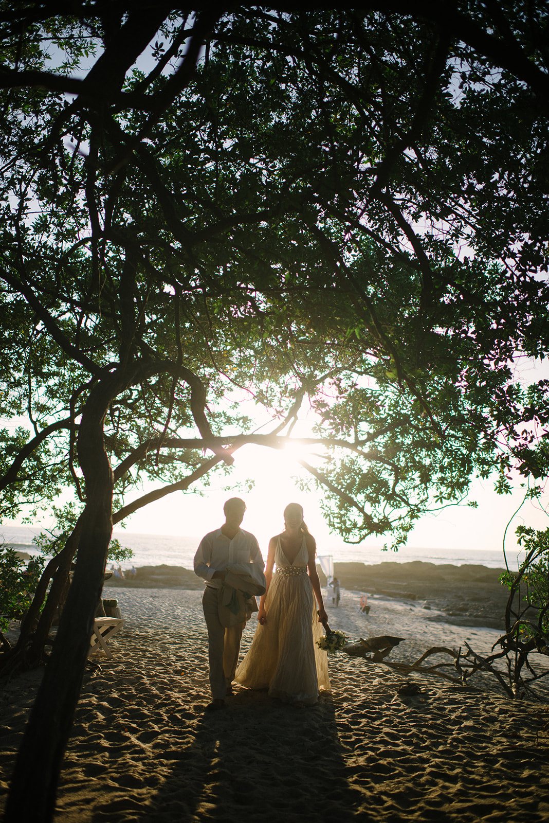 The couple silhouetted under the trees