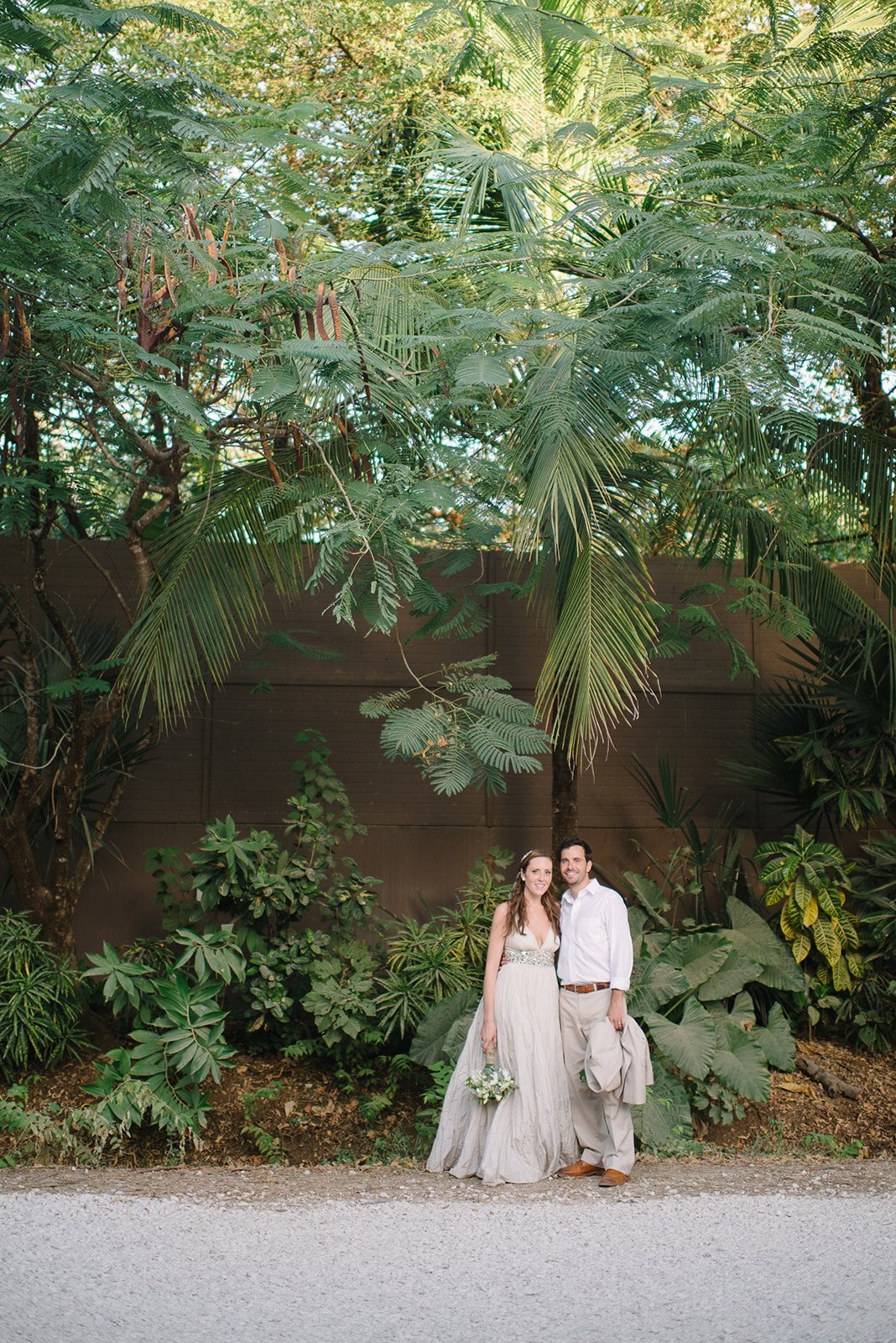 The couple small beneath the jungle