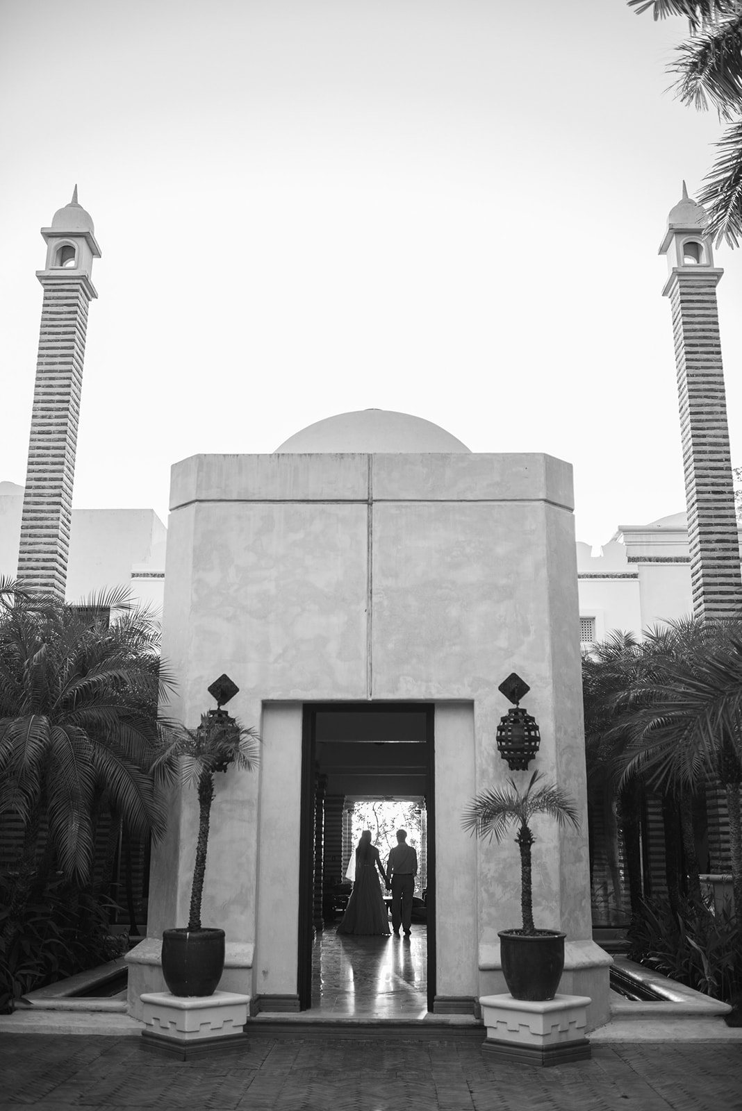 A couple in a white archway, in black and white