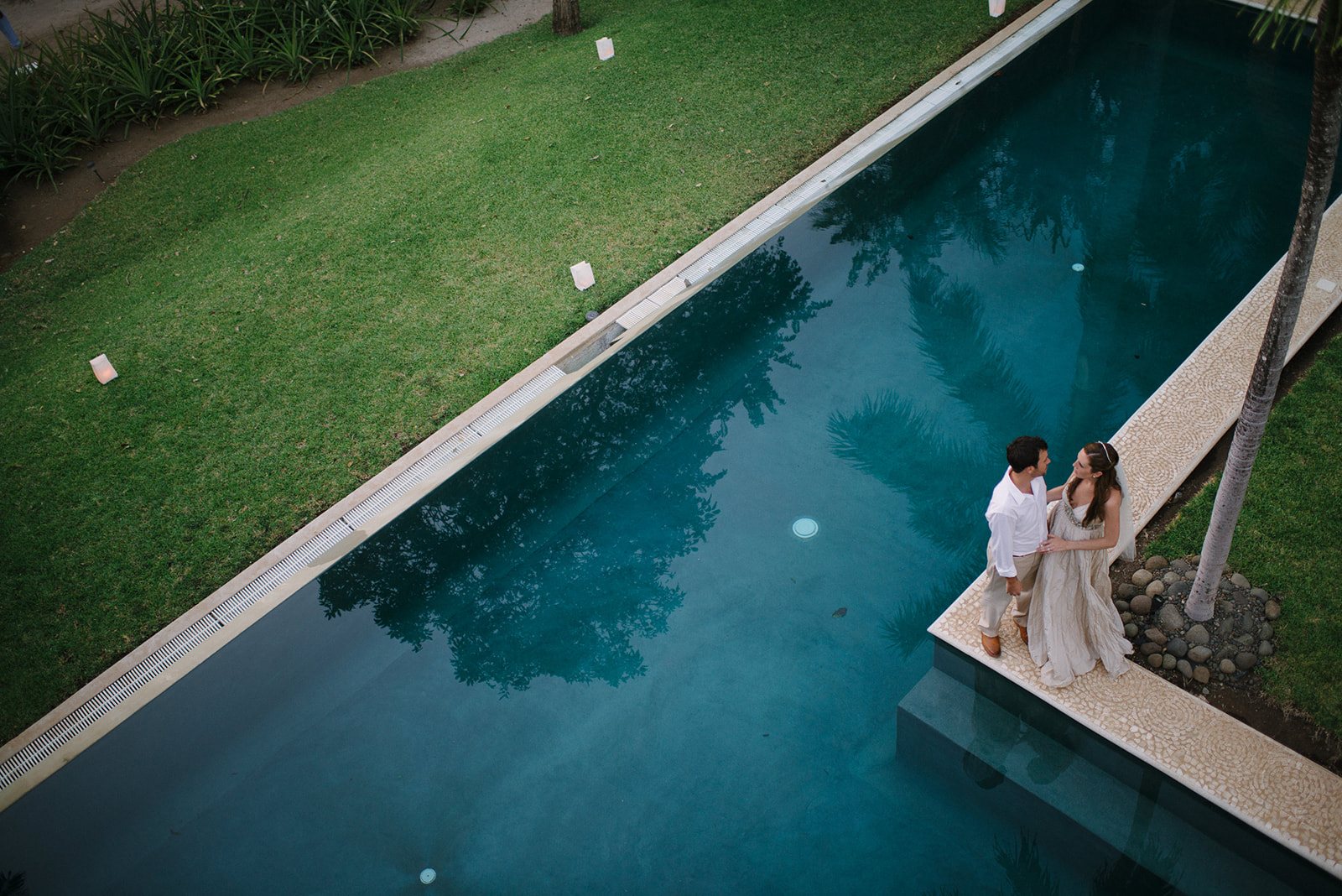 The couple beside the long pool