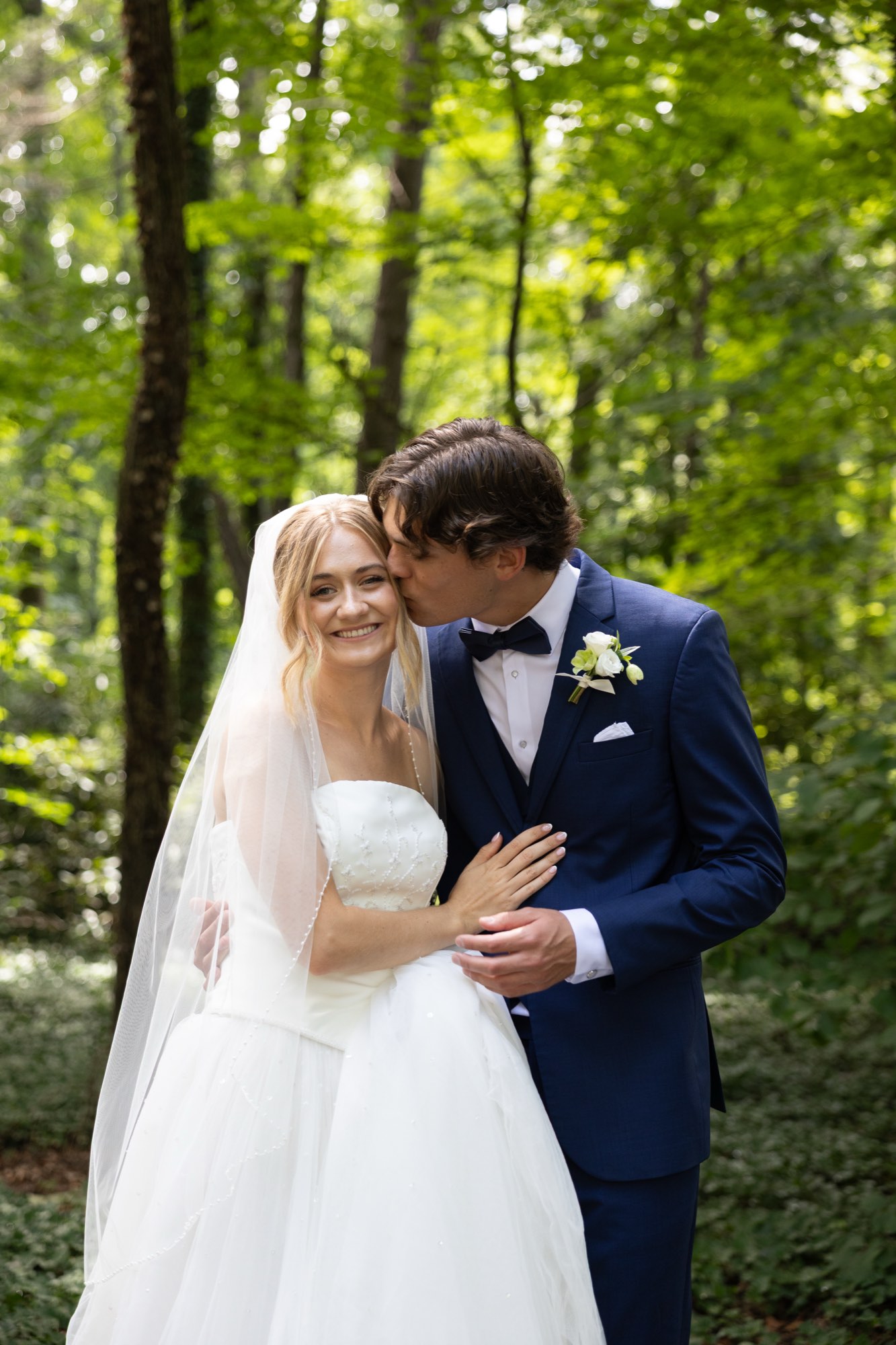 The couple forehead to forehead in the forest