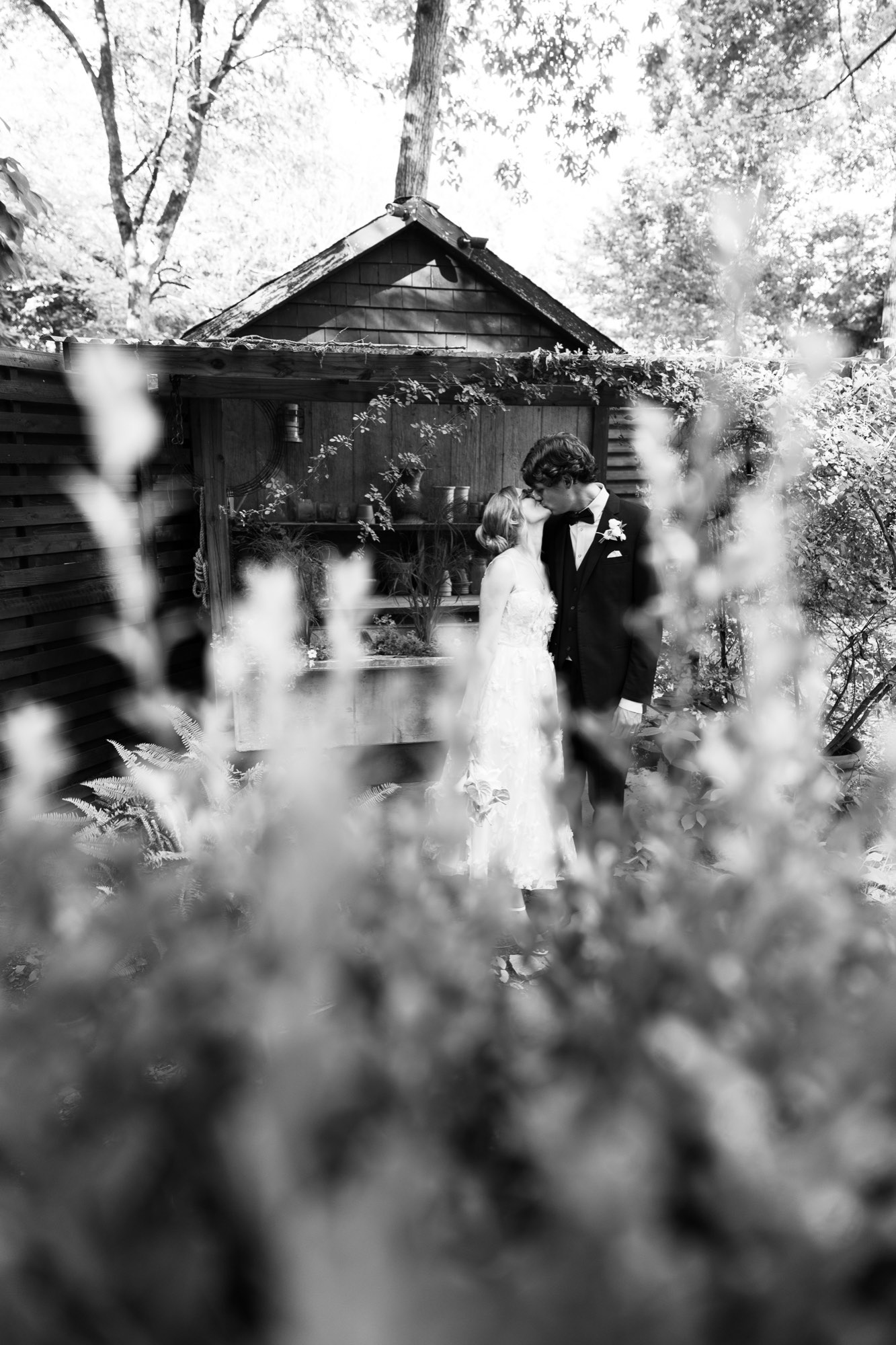 The couple seen through the plants, in black and white