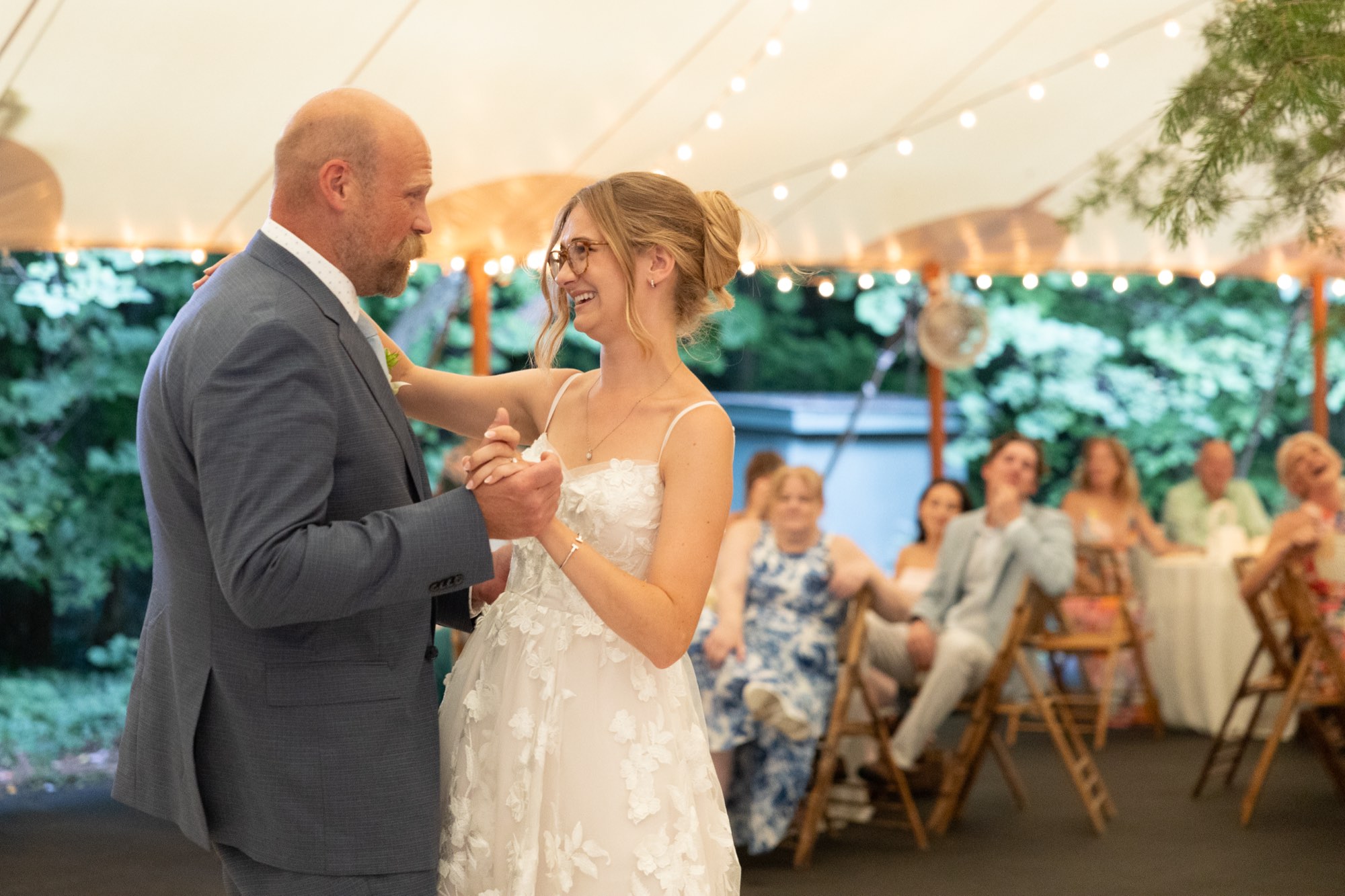 The bride dancing with a guest under the tent