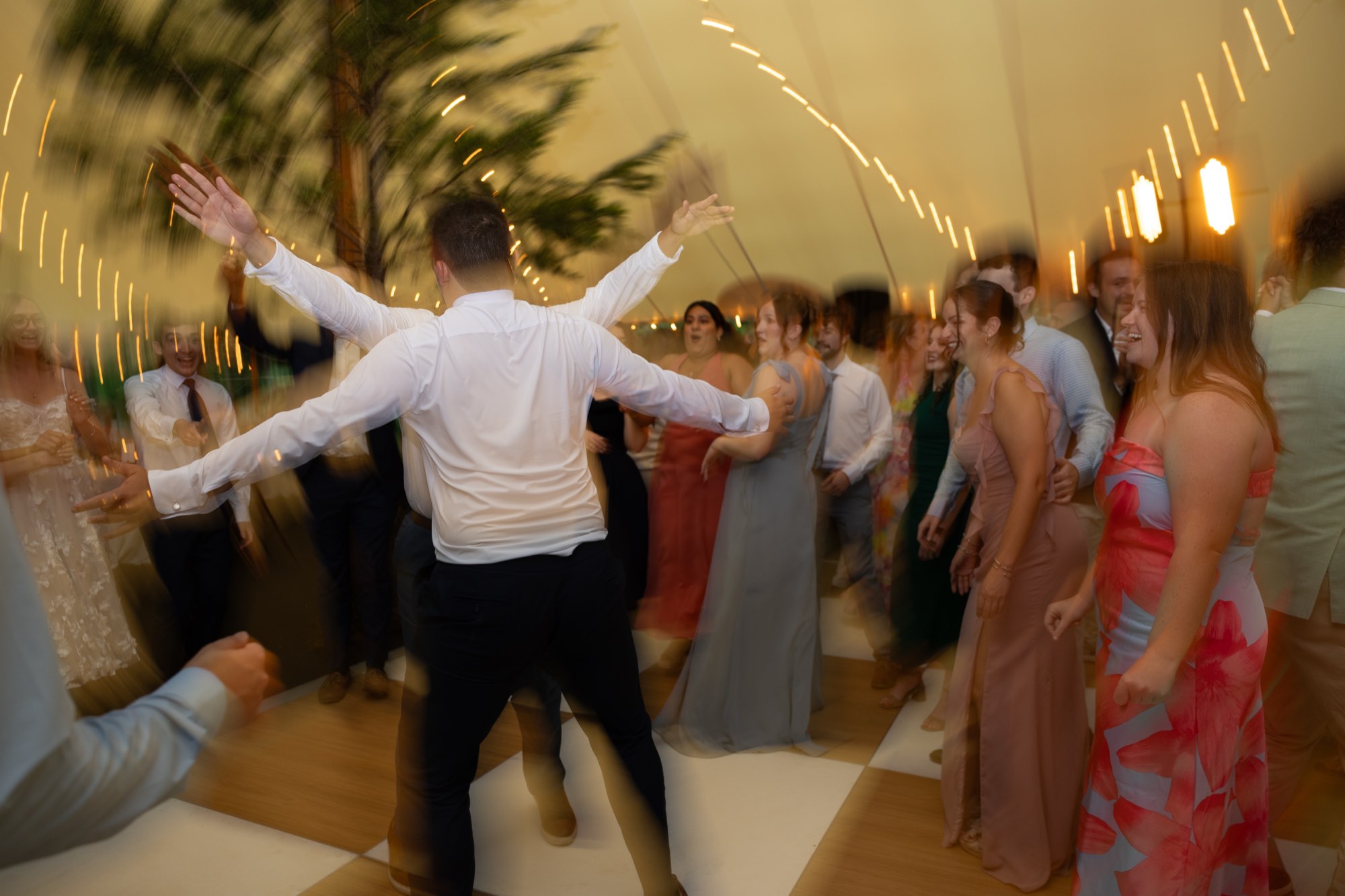 Guests with their arms up on the dance floor