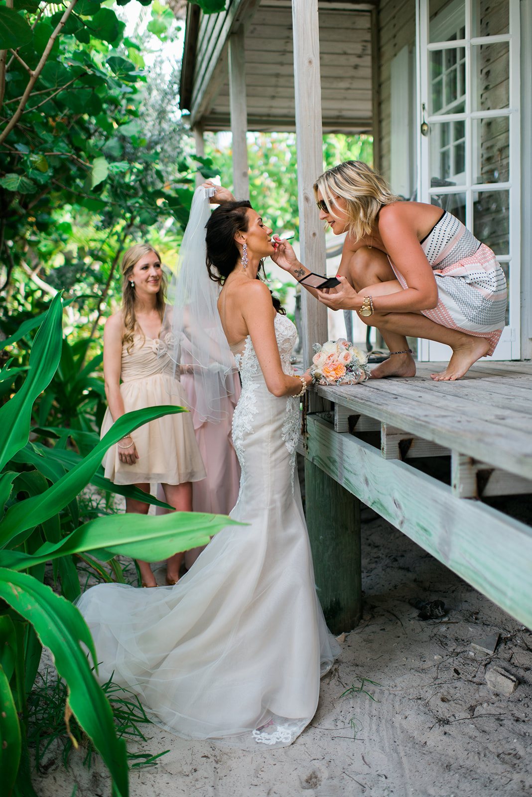 The bride with her bridesmaids on the porch