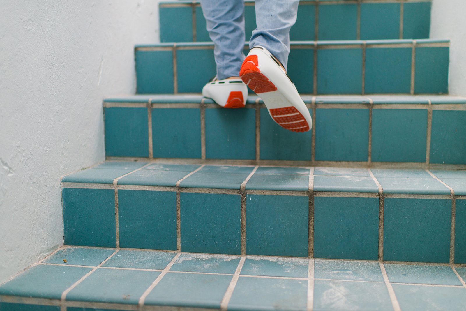 The groom running up the tiled steps