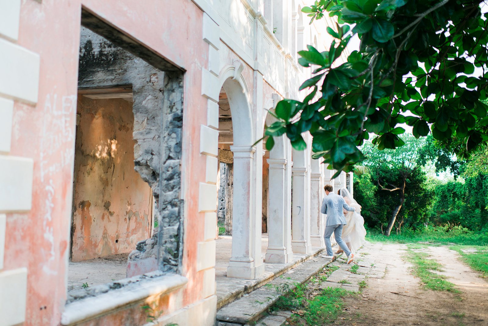 A couple beside a pink stone building