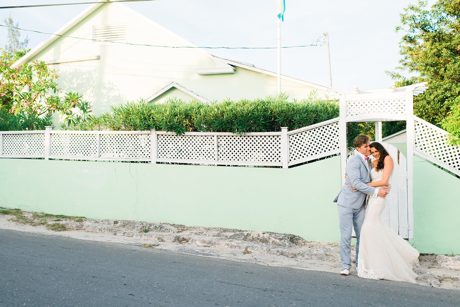 The couple kissing by a mint wall