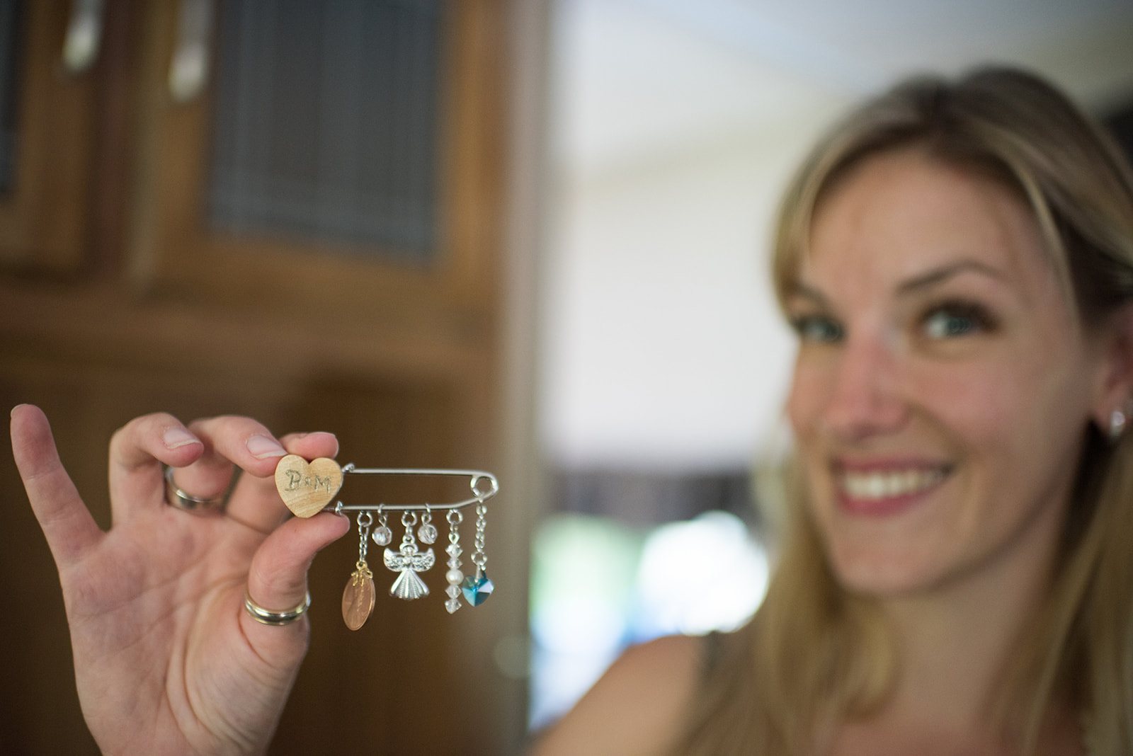 The bride laughing with a charm in her hand