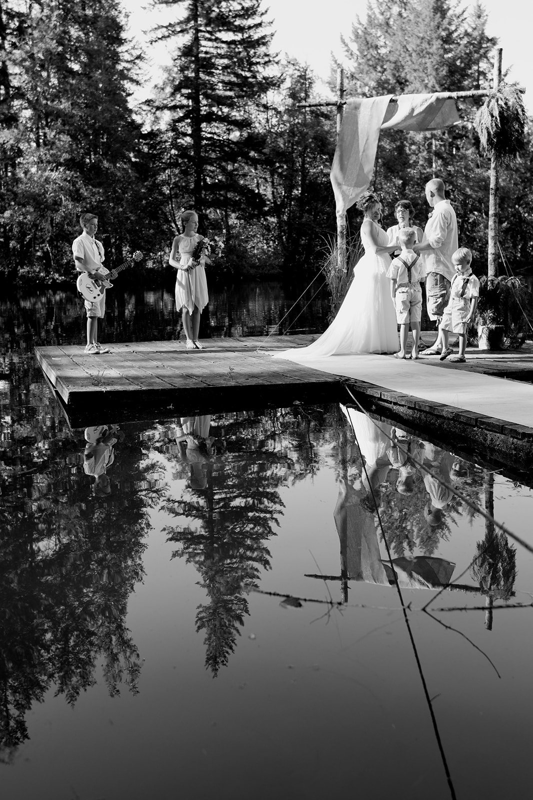 The dock reflected in the lake, in black and white
