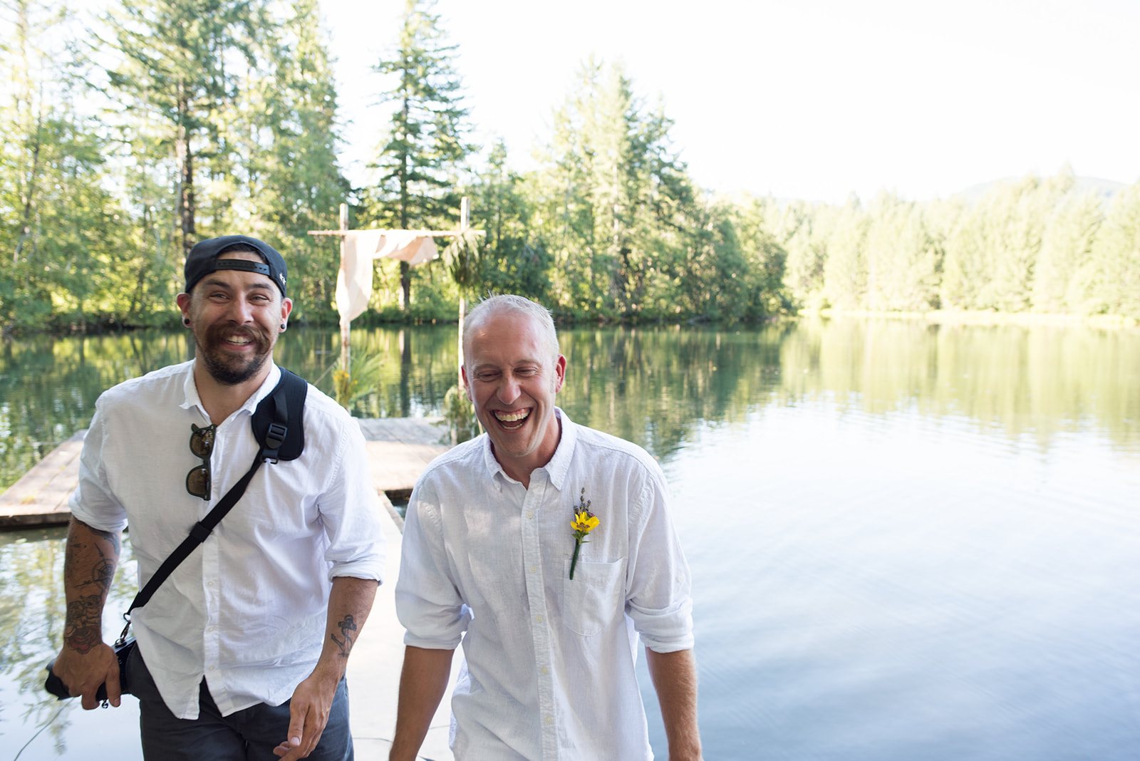 The officiant and the groom by the lake
