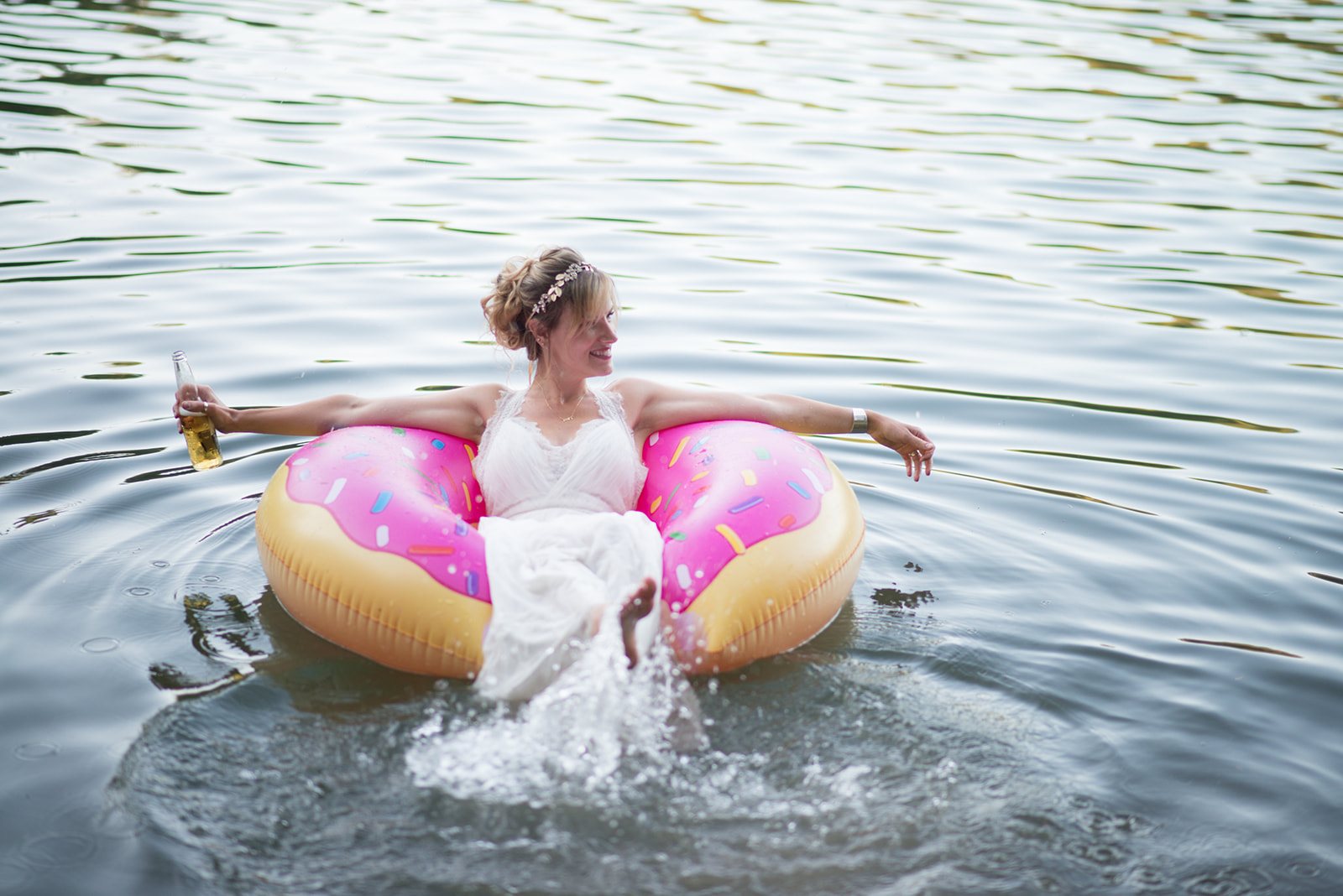The bride in a pink inner tube on the lake