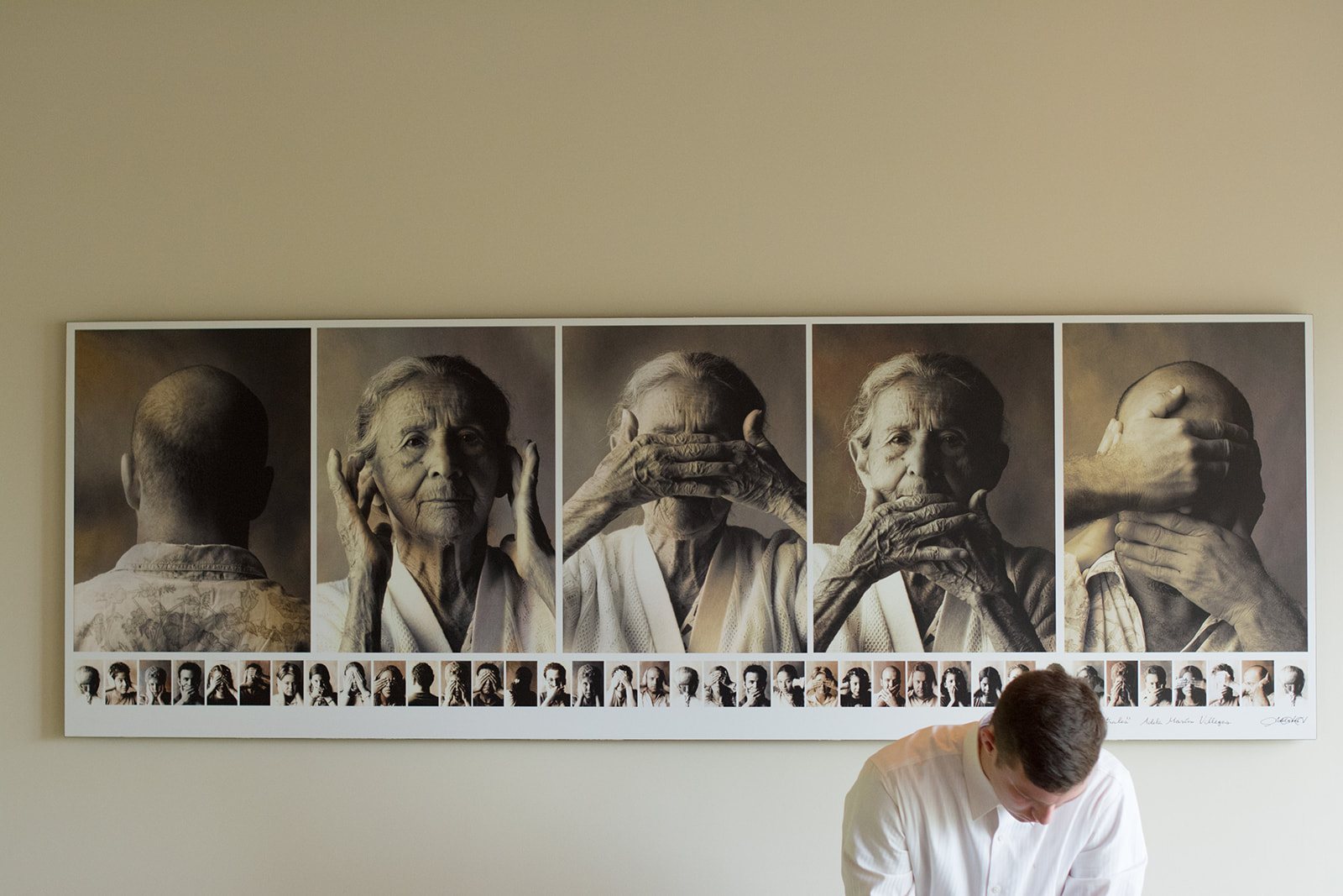 A wall of black and white portraits above a desk