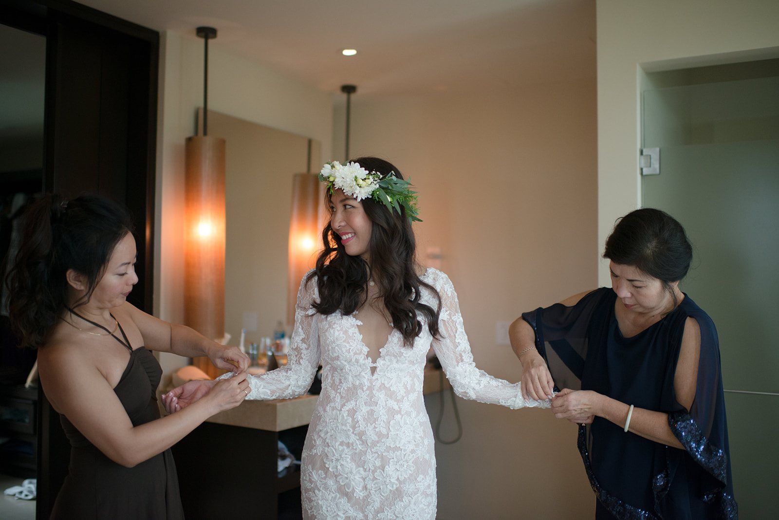 The bride's mother and sister helping her into the gown